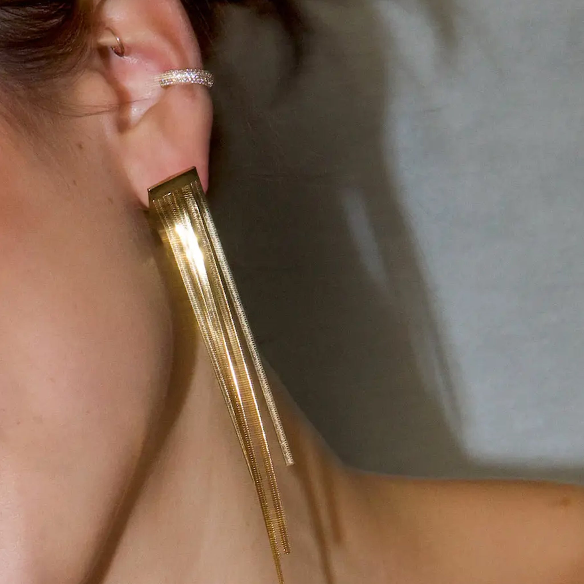 A gold pair of dangle earrings.