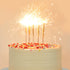 Gold mini sparkling candles lit on top of a birthday cake. 