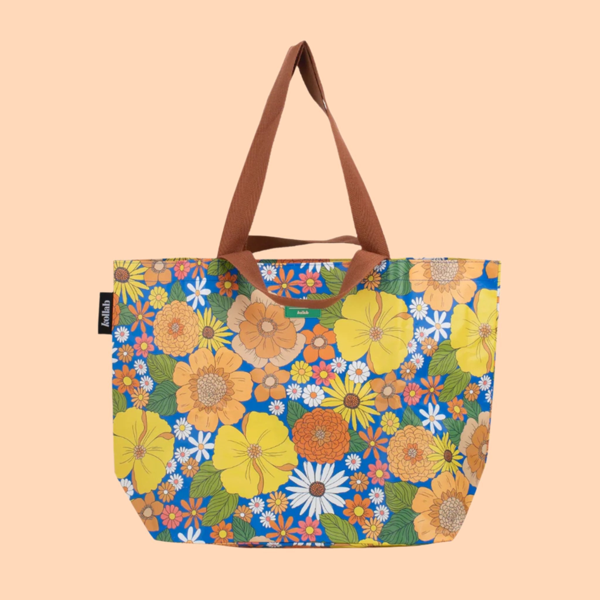 A multi colored floral tote with brown canvas handles. 