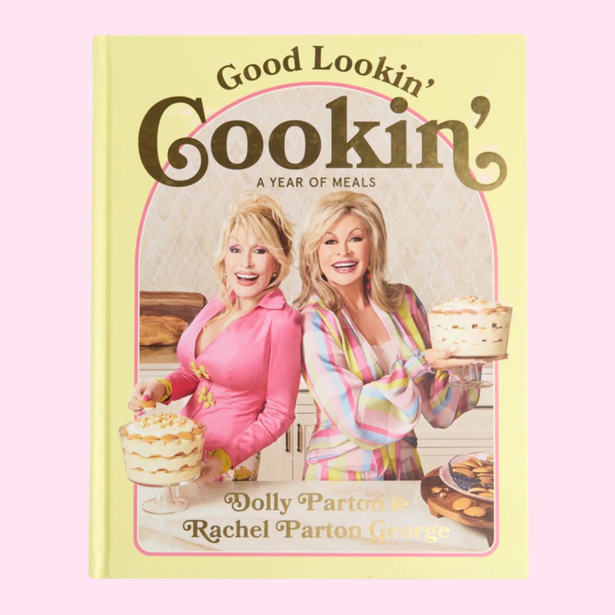 A yellow bookcover with a photo of Dolly Parton and her sister on the cover with text that reads, 'Good Lookin' Cookin' A Year of Meals'.