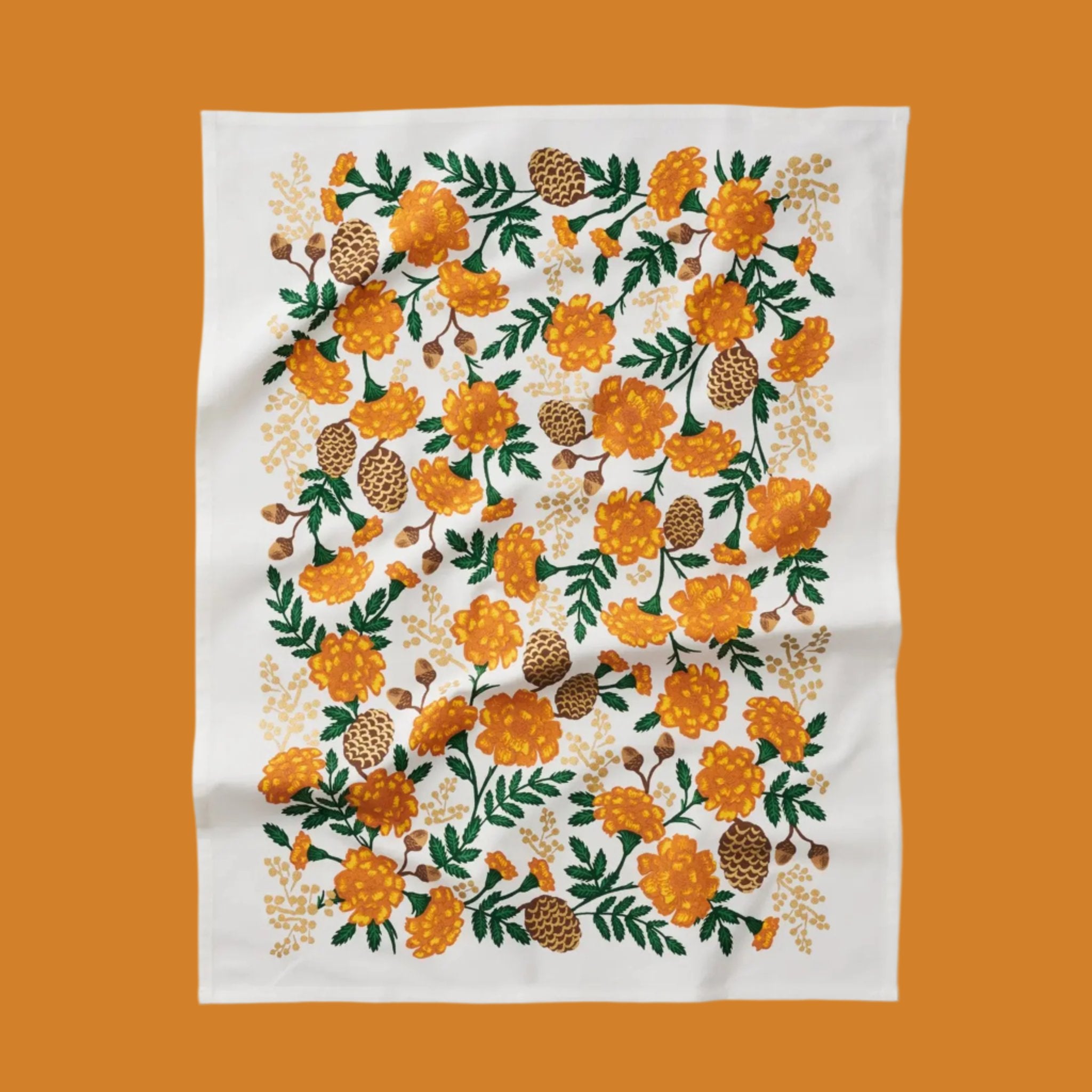 A white tea towel with an orange floral print. 