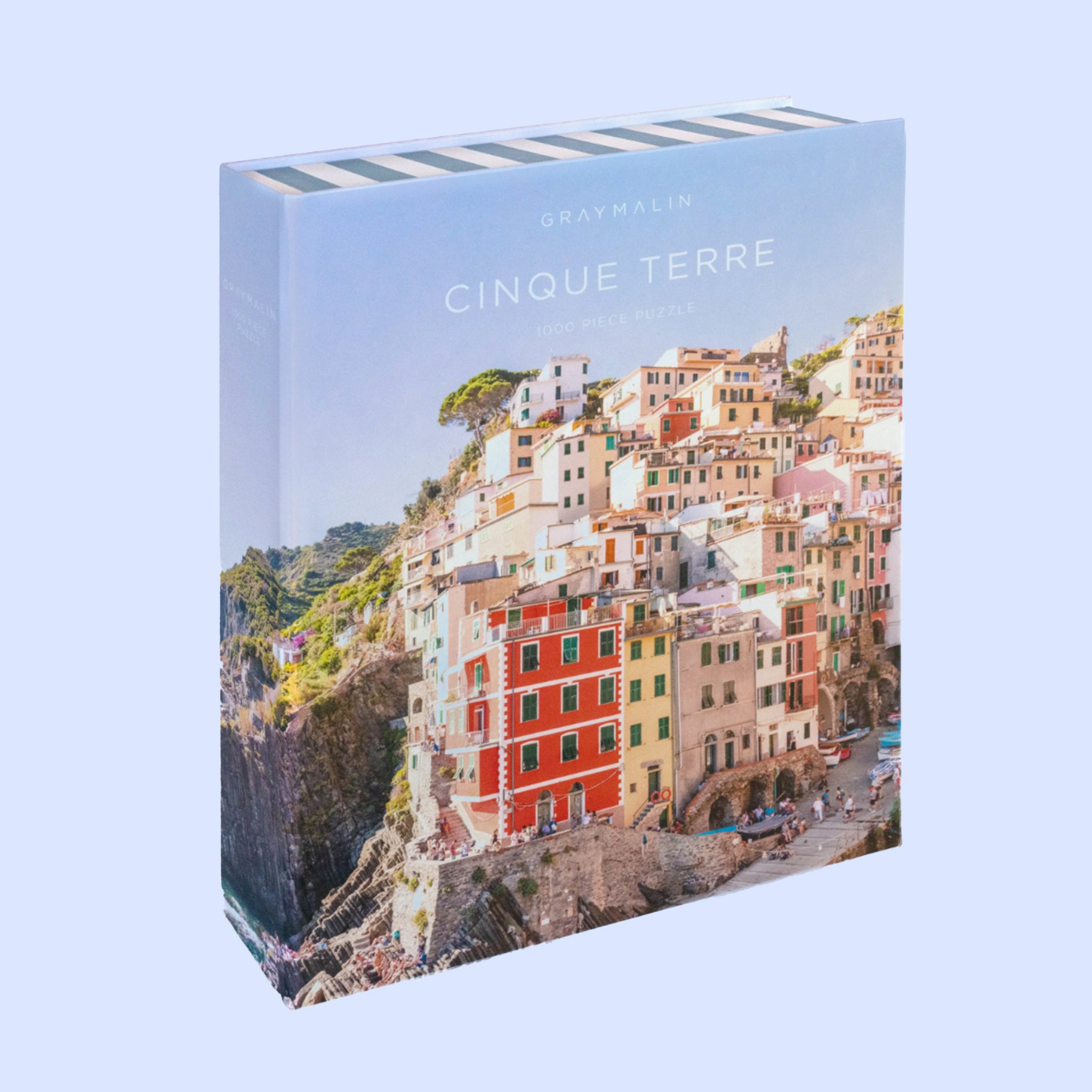 A puzzle box that looks like a book cover with a photograph of a cliffside in Cinque Terre and text that reads, &#39;Gray Malin Cinque Terre&#39;. 