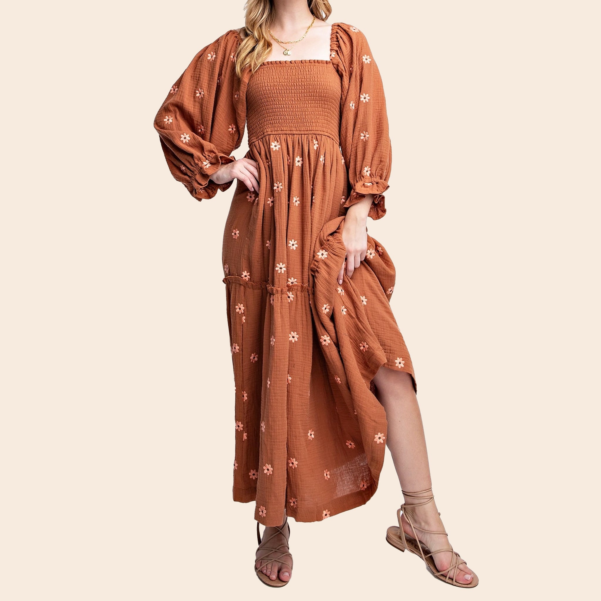 A rust / brown long-sleeve dress with flower embroidery. 