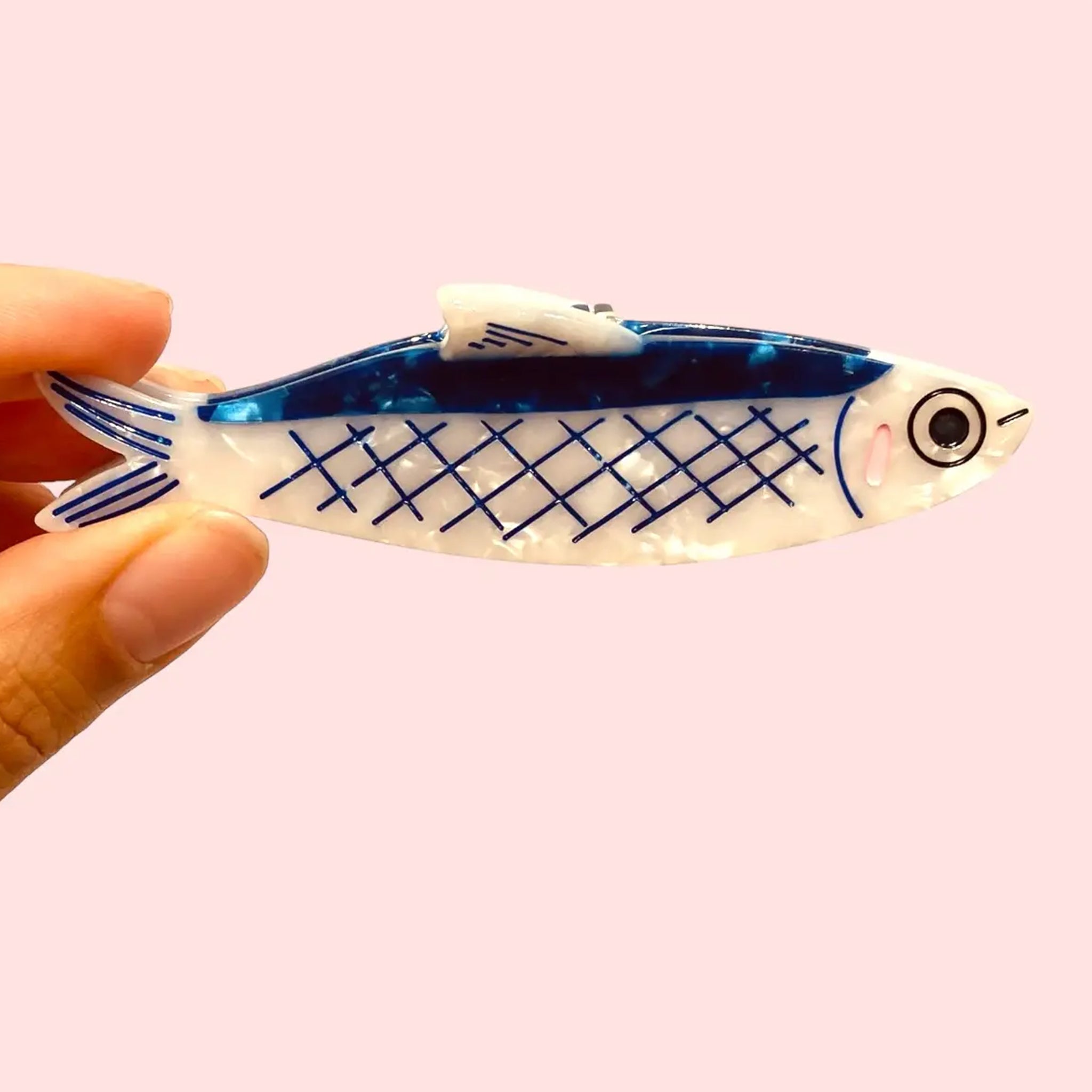 A blue and pearly anchovy shaped hair claw clip. 