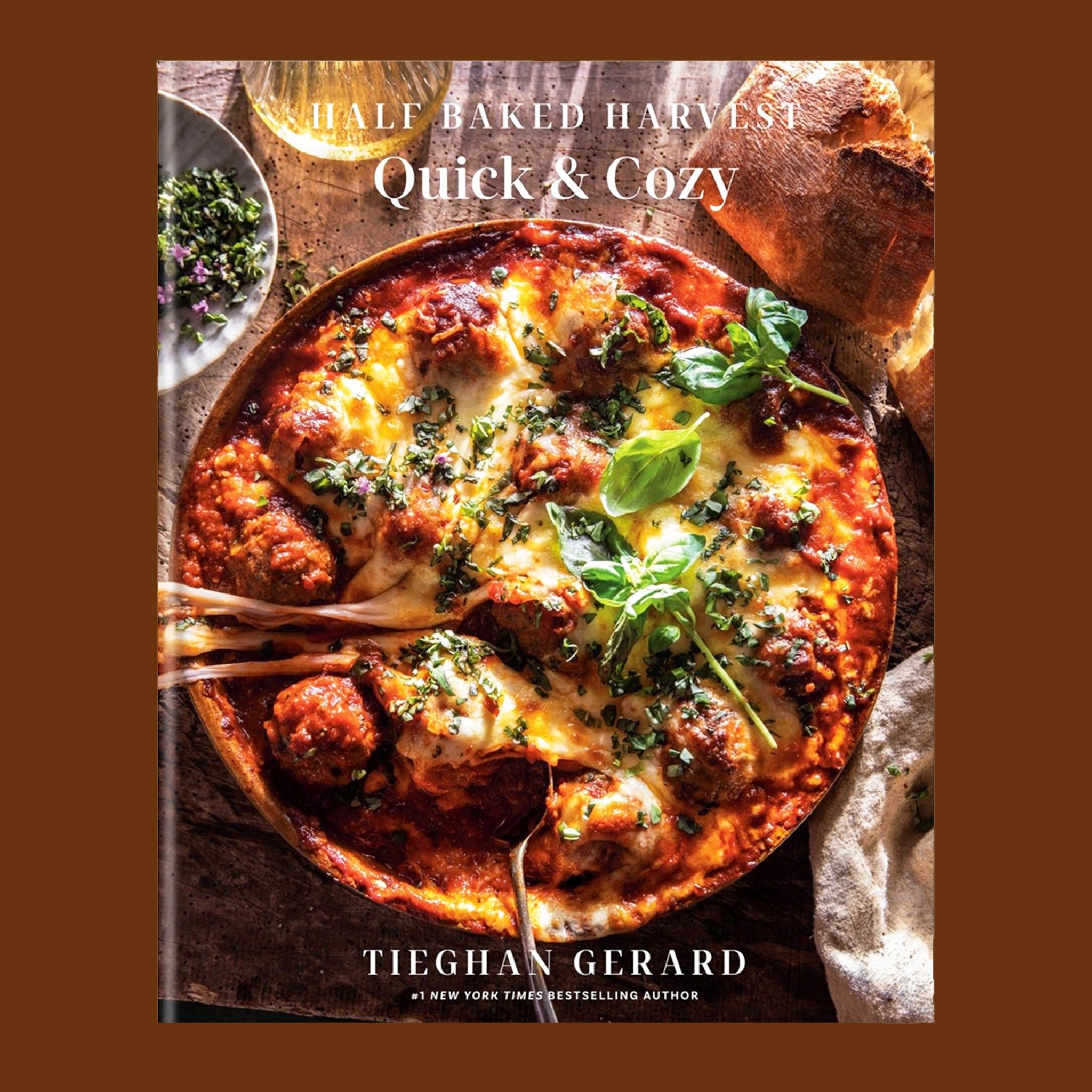 A book cover with a photo of a cozy food dish and white text above that reads, 'Half Baked Harvest Quick & Cozy'. 