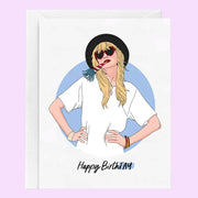 On a purple background is a white card with an illustration inspired by Taylor Swift in a hat, heart shaped sunglasses and text underneath that reads, "Happy BirthTAY". 