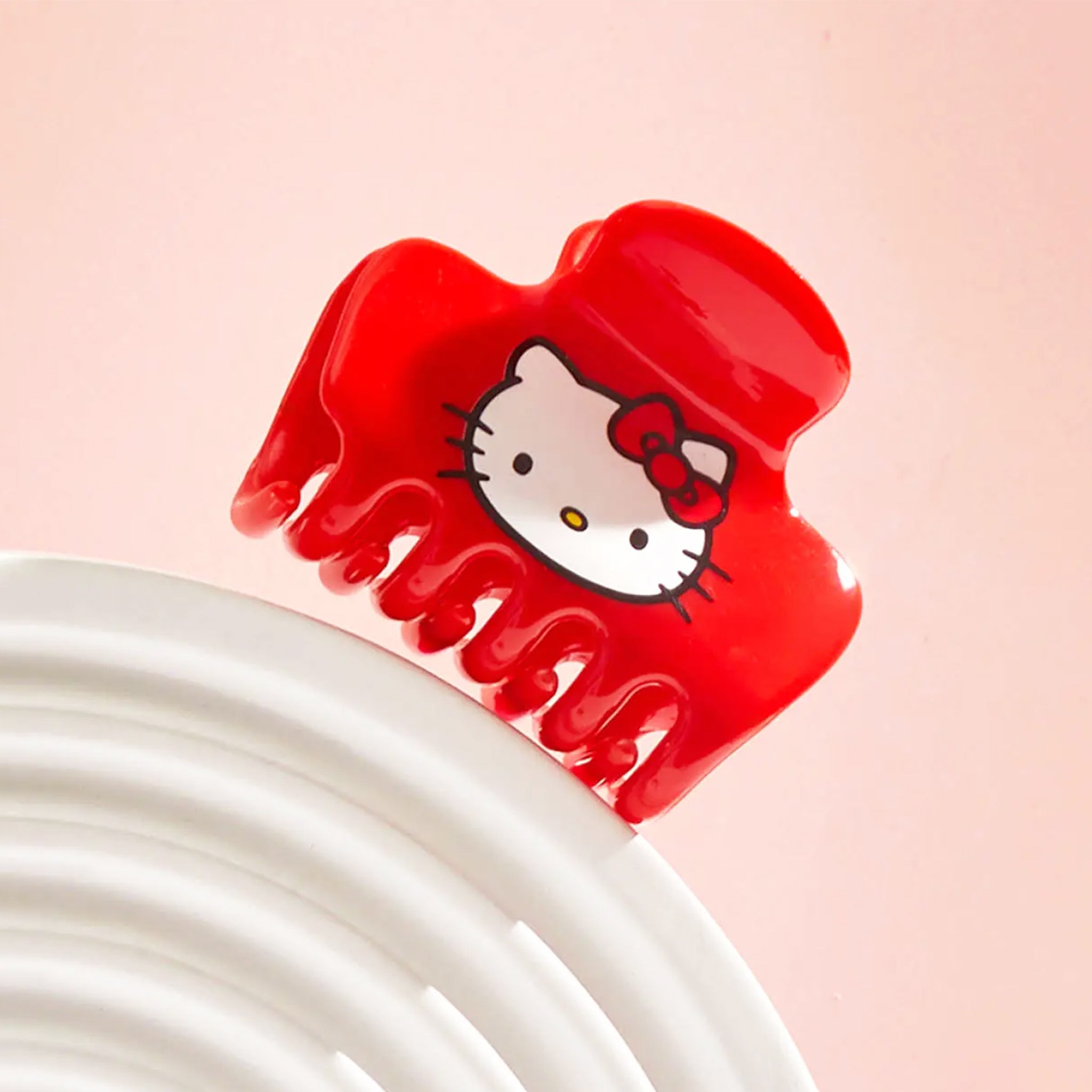 A red claw clip with a hello kitty fcae on the side. 