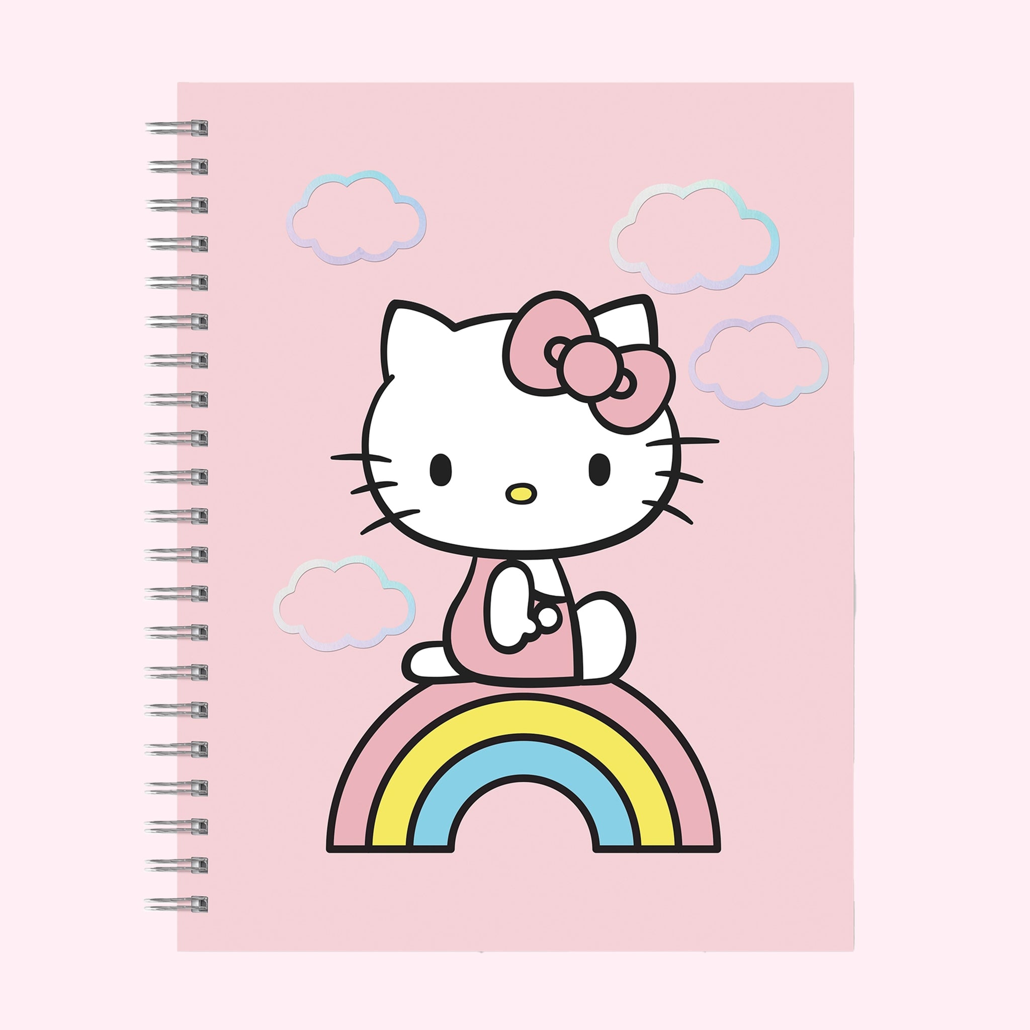 A pink spiral bound notebook with a graphic of Hello Kitty in the center standing on a multi colored rainbow. 