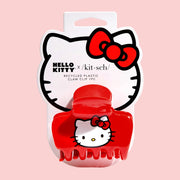 A red claw clip with a hello kitty fcae on the side.