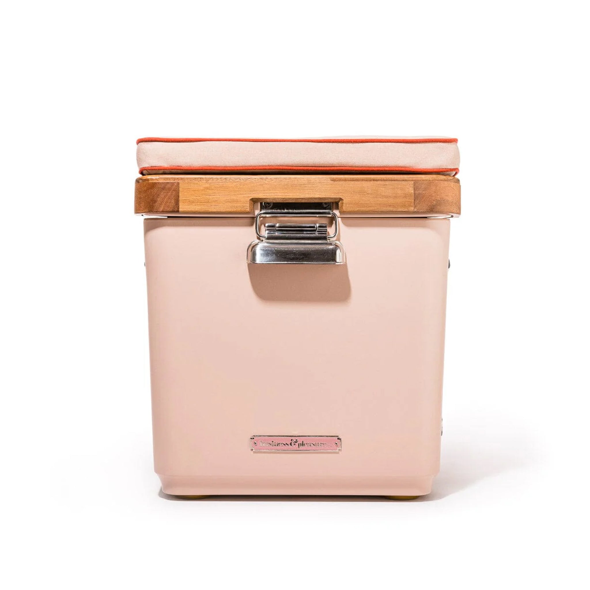 A light pink cooler with beautiful silver and gold details and a pink cushion on top.