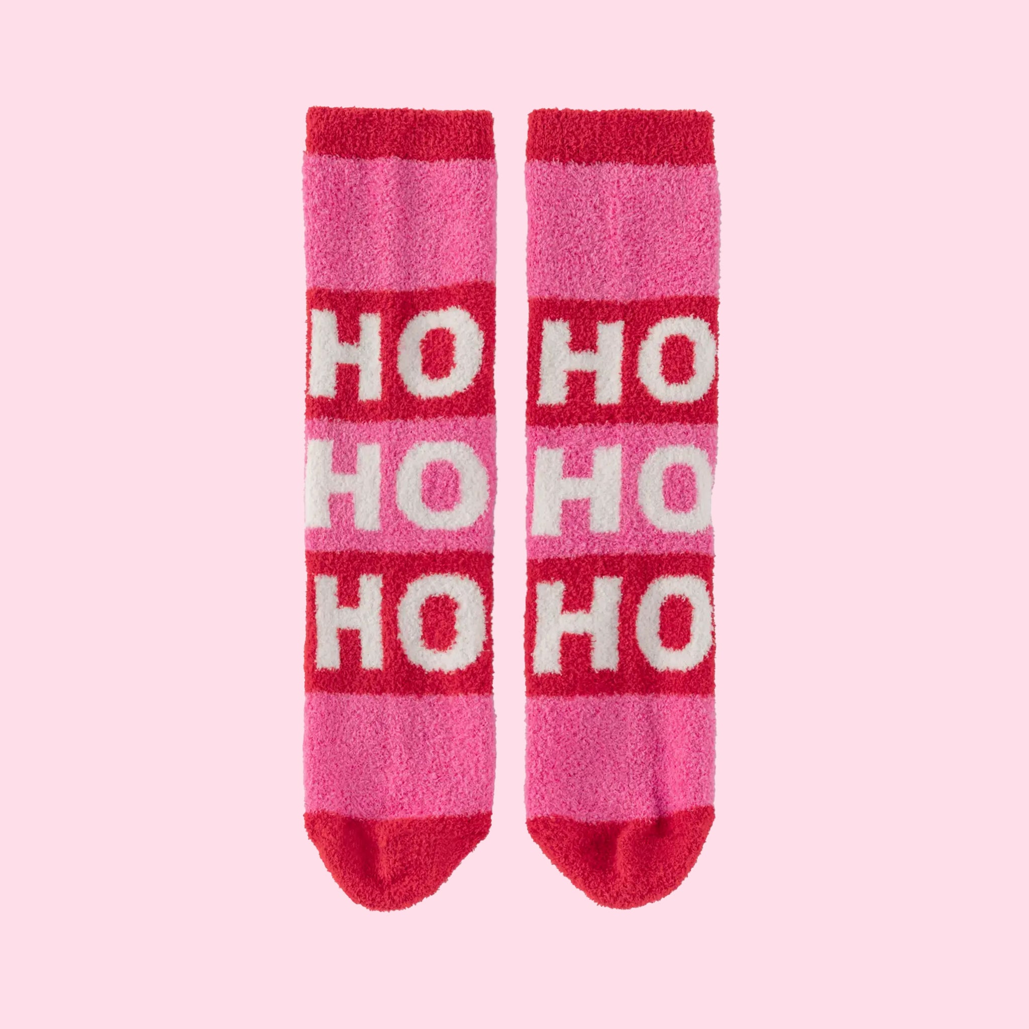 A pair of pink and red fuzzy socks that read, &#39;Ho Ho Ho&#39; in white text down the front. 