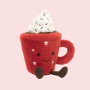 A red mug shaped stuffed toy with a whipped topping and a smiling face. 