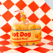 A hot dog buns shaped ornament with a red loop for hanging. 