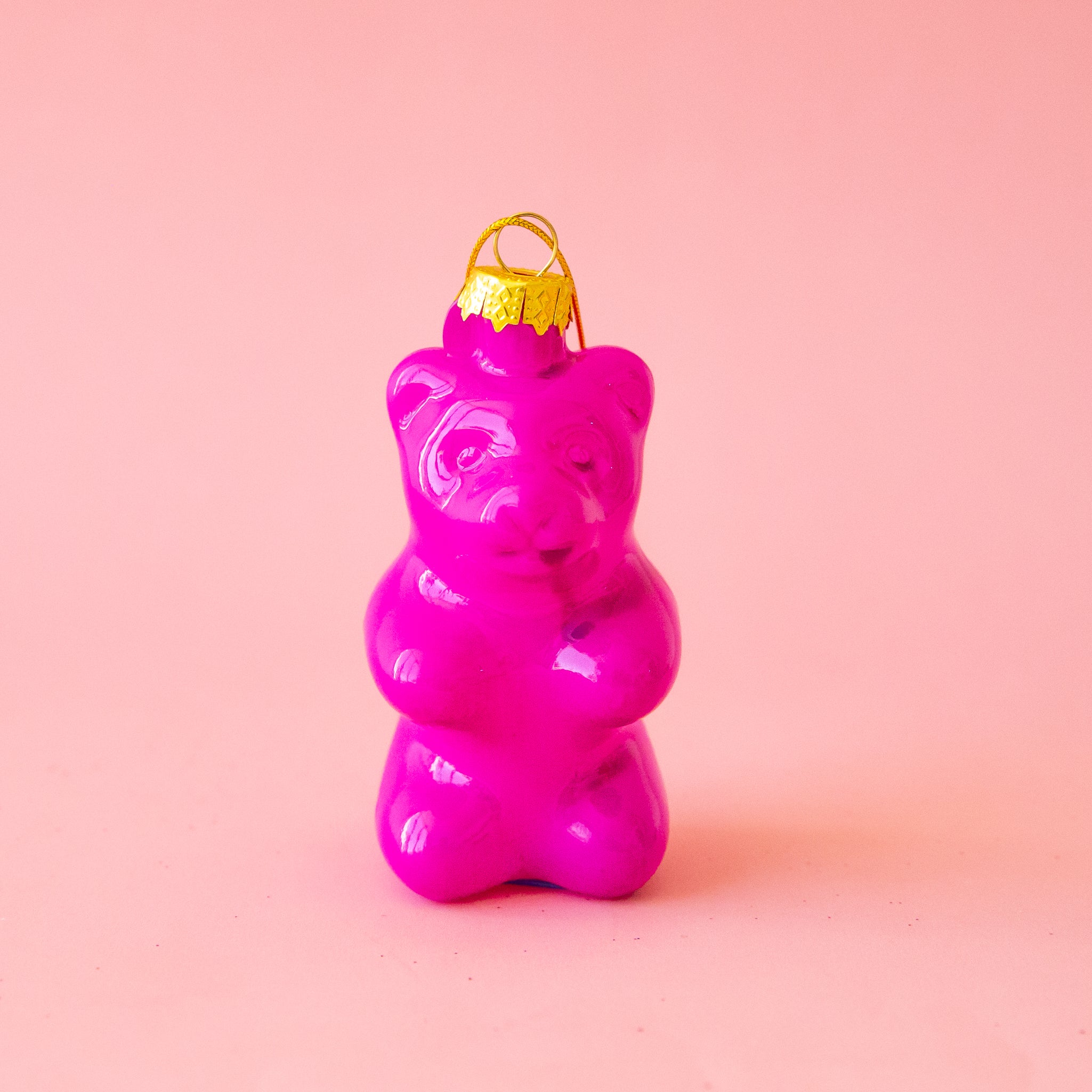 A hot pink glass gummy bear shaped ornament. 