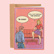 A pink  card with a couple looking at each other with speech bubbles. One speech bubble reads, 'I'm hungry' and the other responds, 'Yeah, I got something you can eat'. 