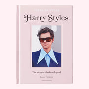 A light pink book with a photo of Harry Styles and text above and below that reads, "Harry Styles The story of a fashion legend". 