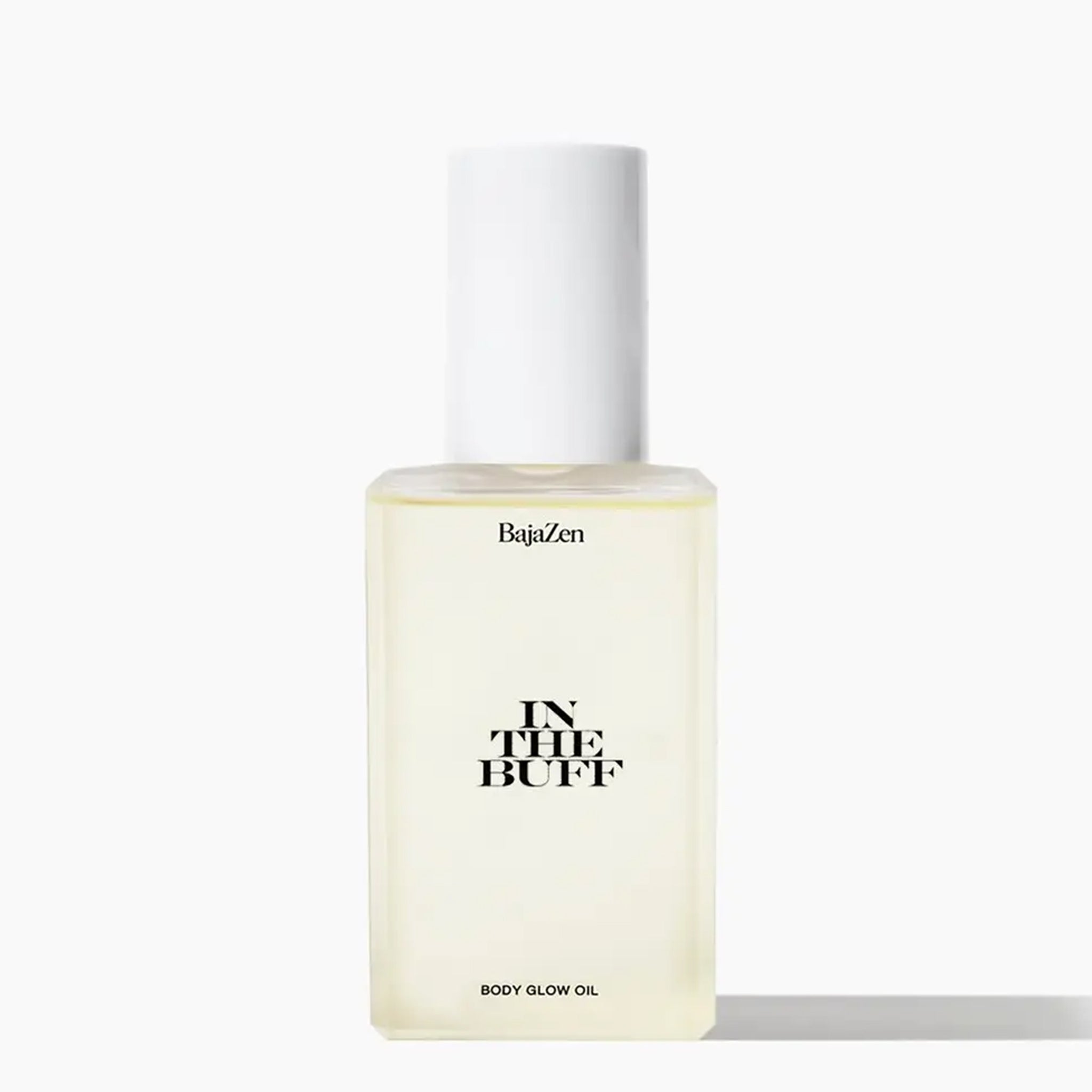 A clear packaging of body oil with a white lid and black text that reads, &quot;In The Buff&quot;.