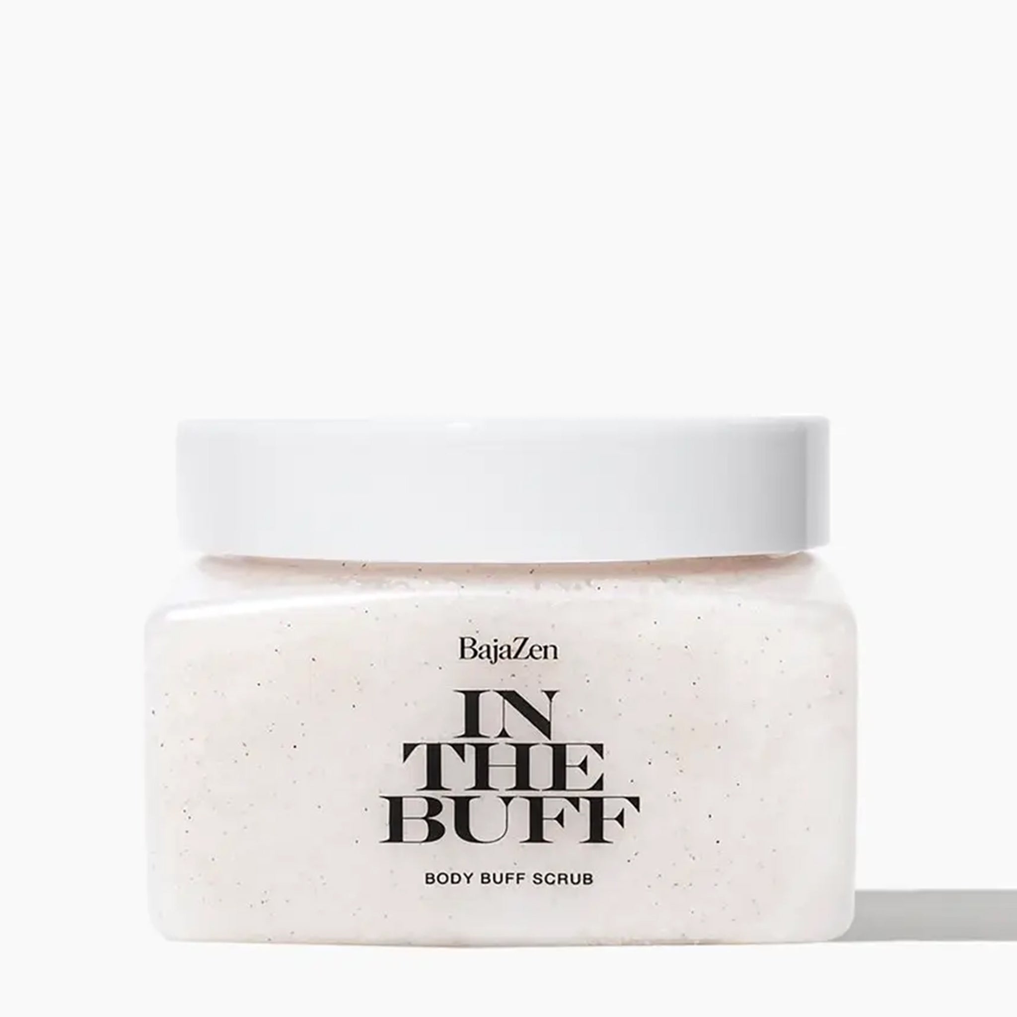 A clear container filled with a white body scrub with a white lid and black text that reads, &quot;In The Buff Body Buff Scrub&quot;. 