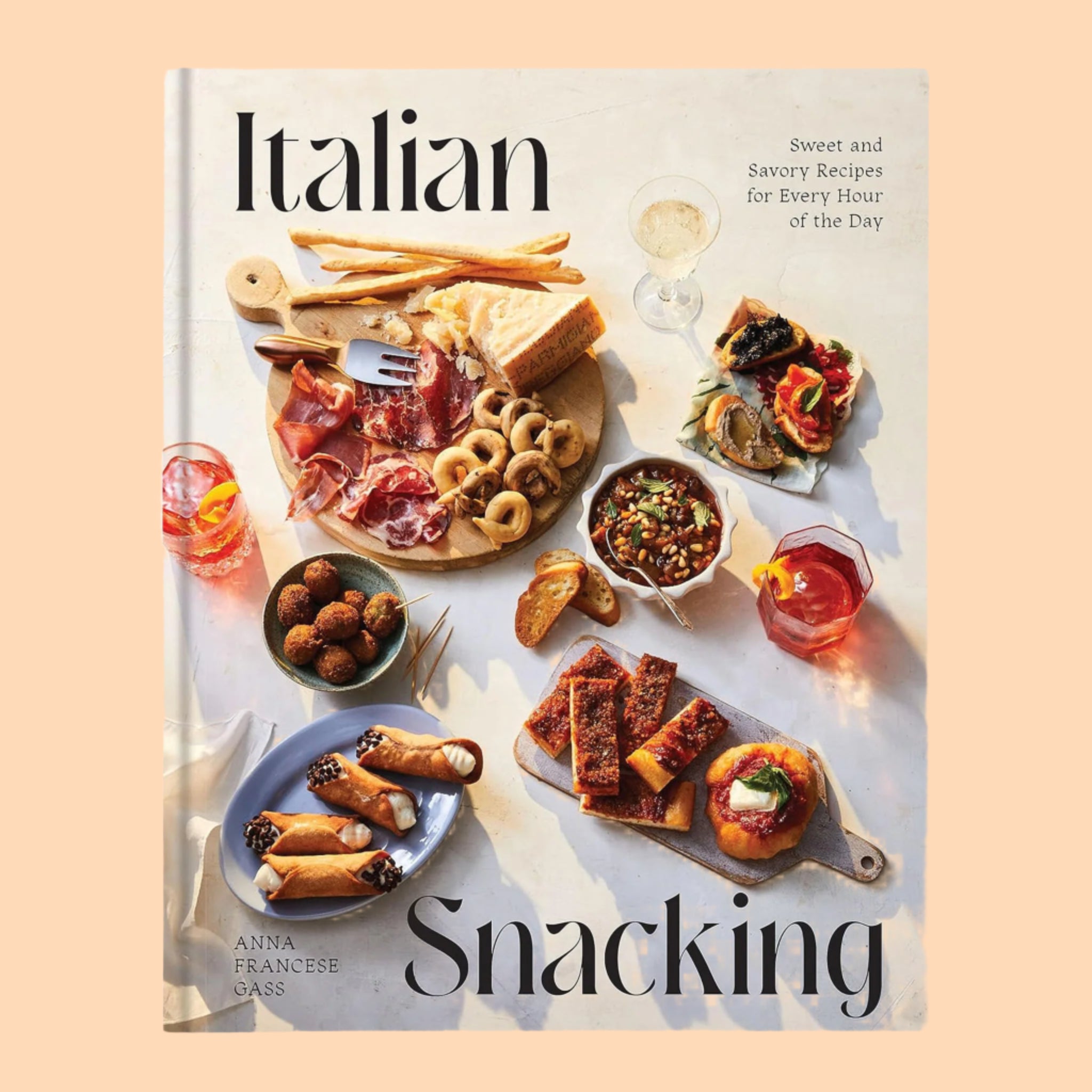 A neutral book cover with a spread of Italian small bites and black text that reads, &quot;Italian Snacking&#39;. 