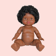 A baby girl doll with black curly hair and brown eyes. 