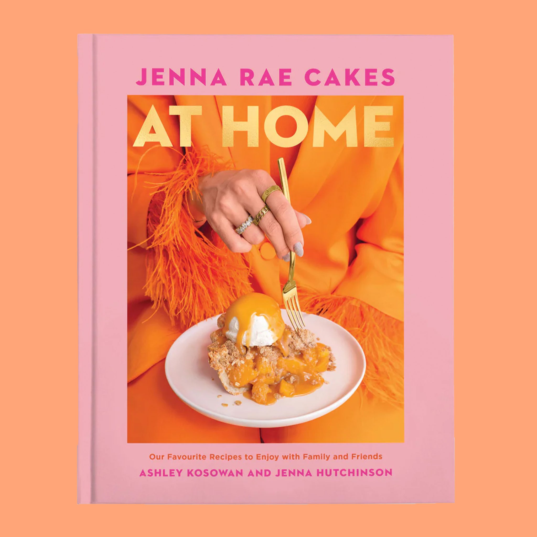 A pink and orange book cover with a model holding a piece of fruit pie and text that reads, 'Jenna Rae Cakes At Home'. 