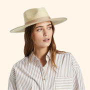 A neutral tan and natural colored rancher hat. 