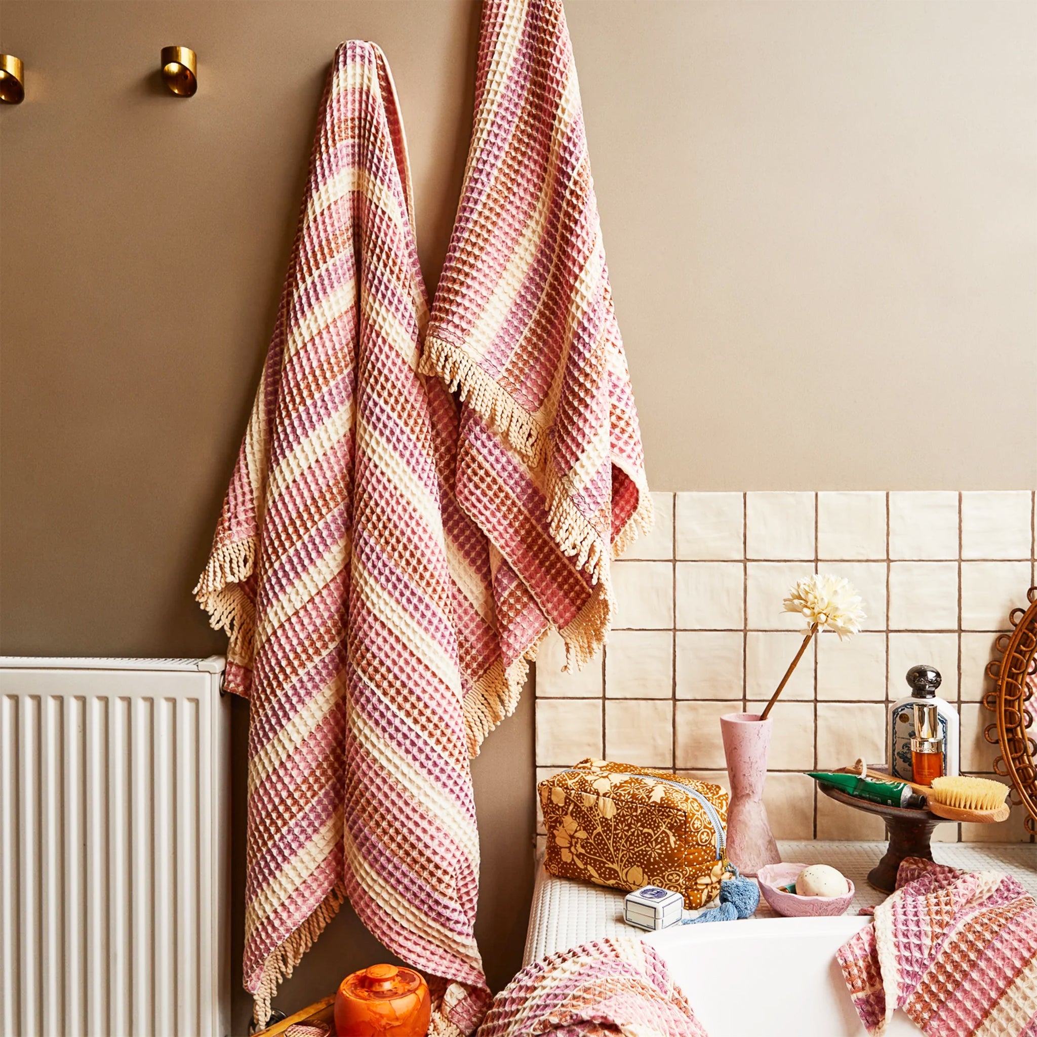 A pink striped waffle knit bath towel. 