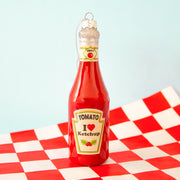 A red glass ketchup bottle shaped ornament. 