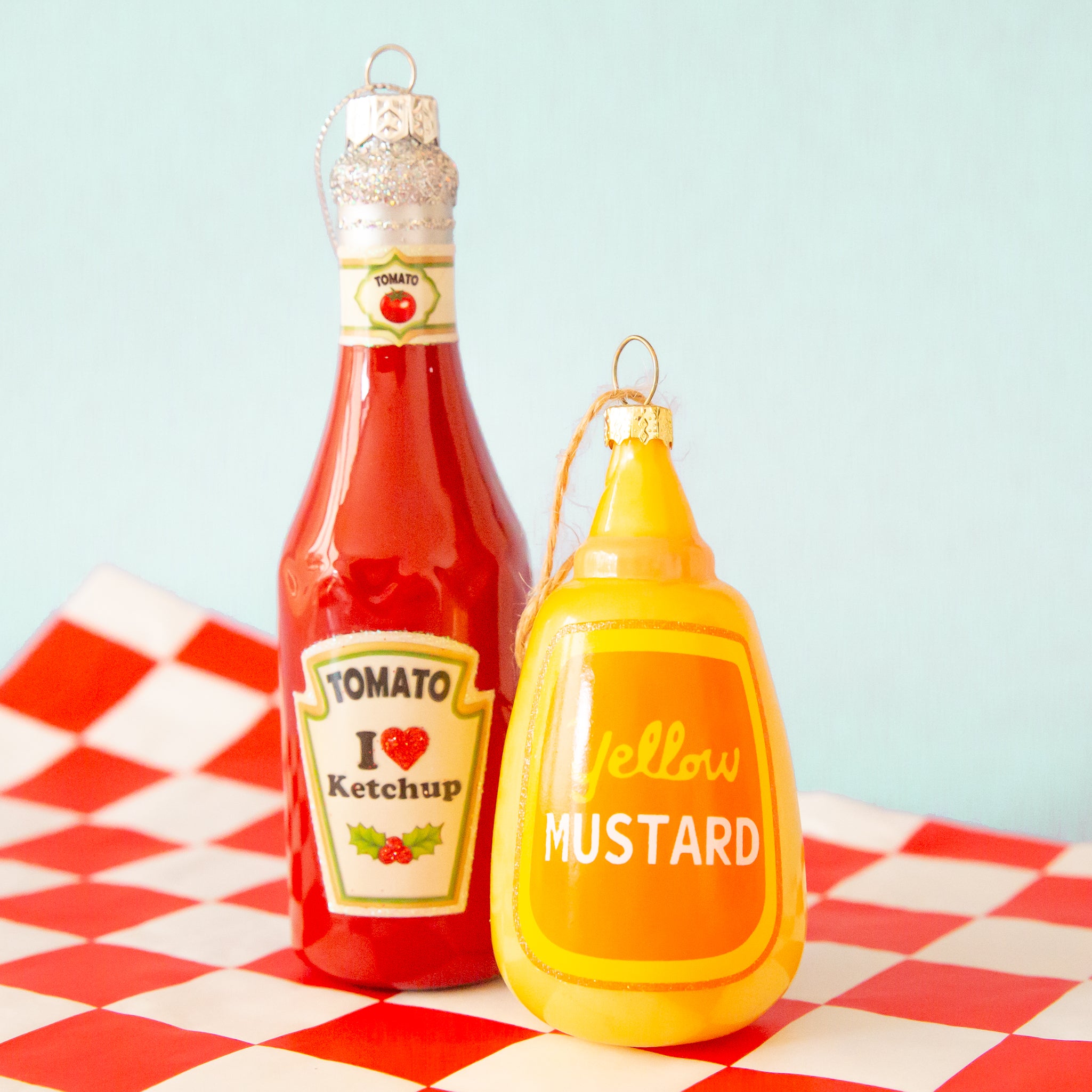 A glass mustard and ketchup bottle shaped ornament. Each ornament sold separately. 