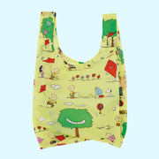 A yellow nylon reusable bag with a Charlie Brown kite eating tree print. 