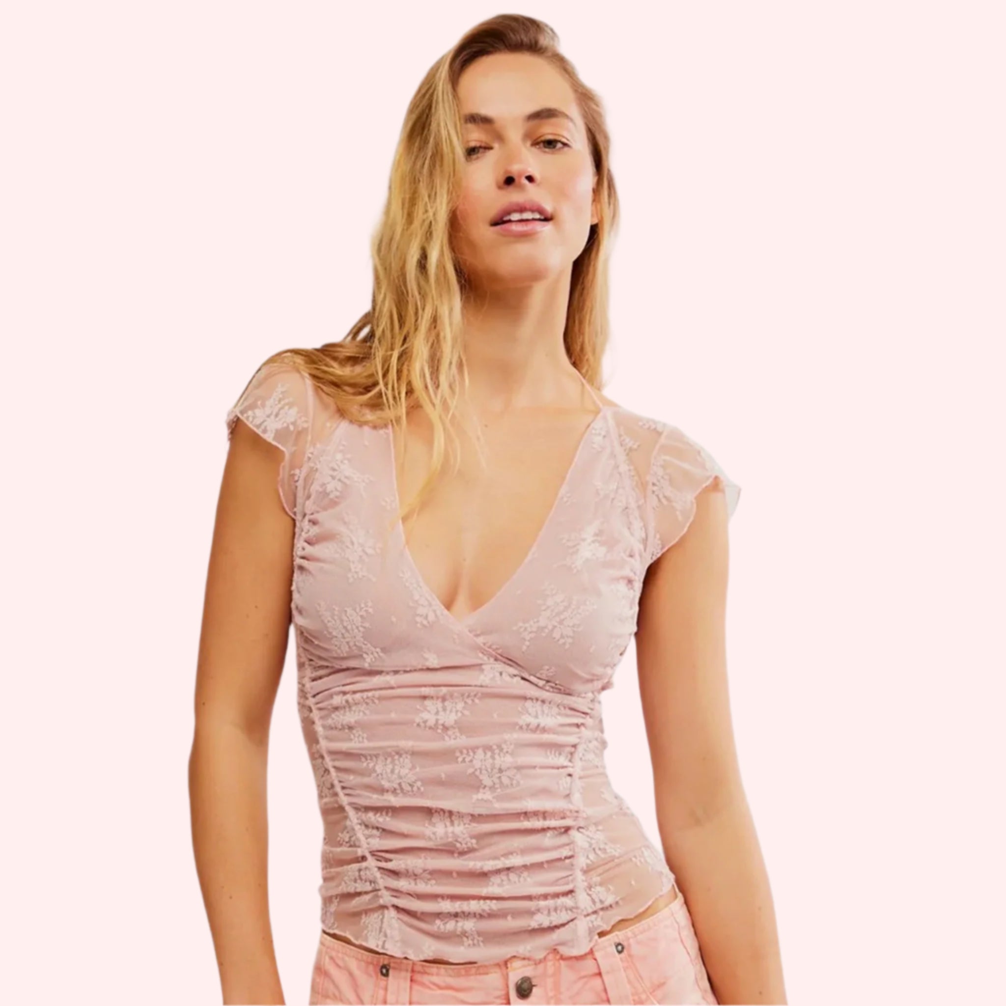 A lacey light pink cami tank top with ruffle details and a v-neck.