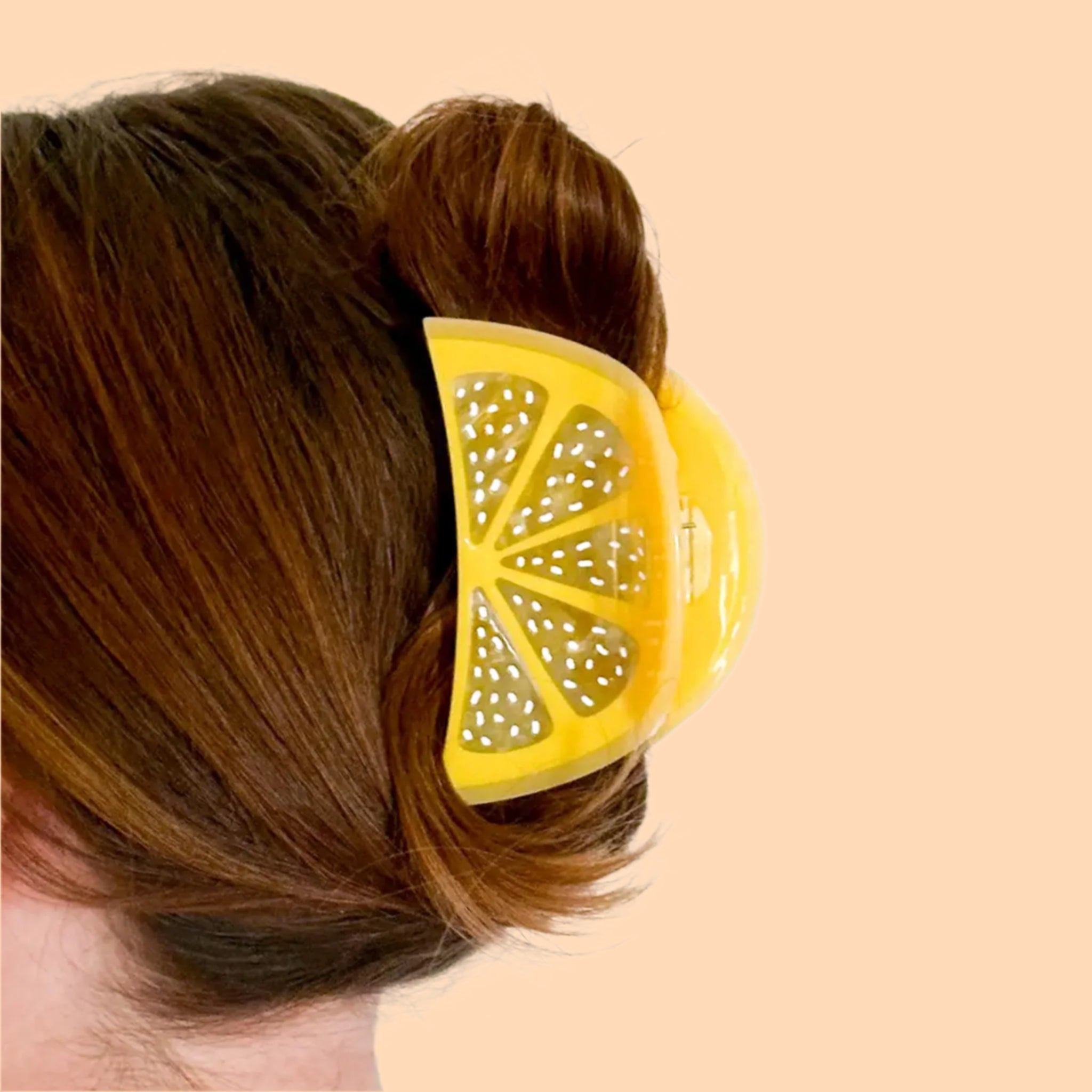 A yellow lemon sliced shape hair claw clip. 