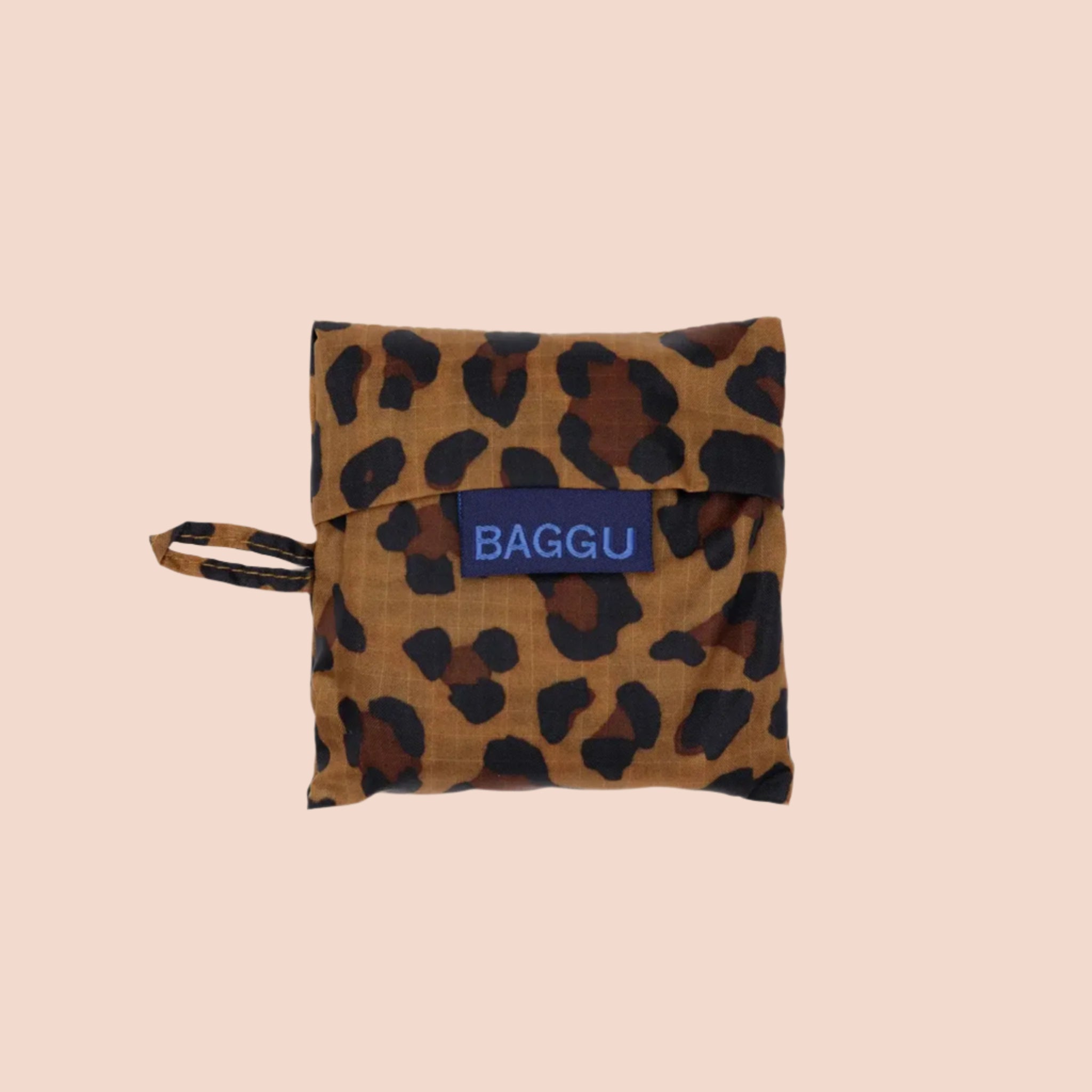 A small nylon tote bag in a leopard print that folds up into a small pouch. 