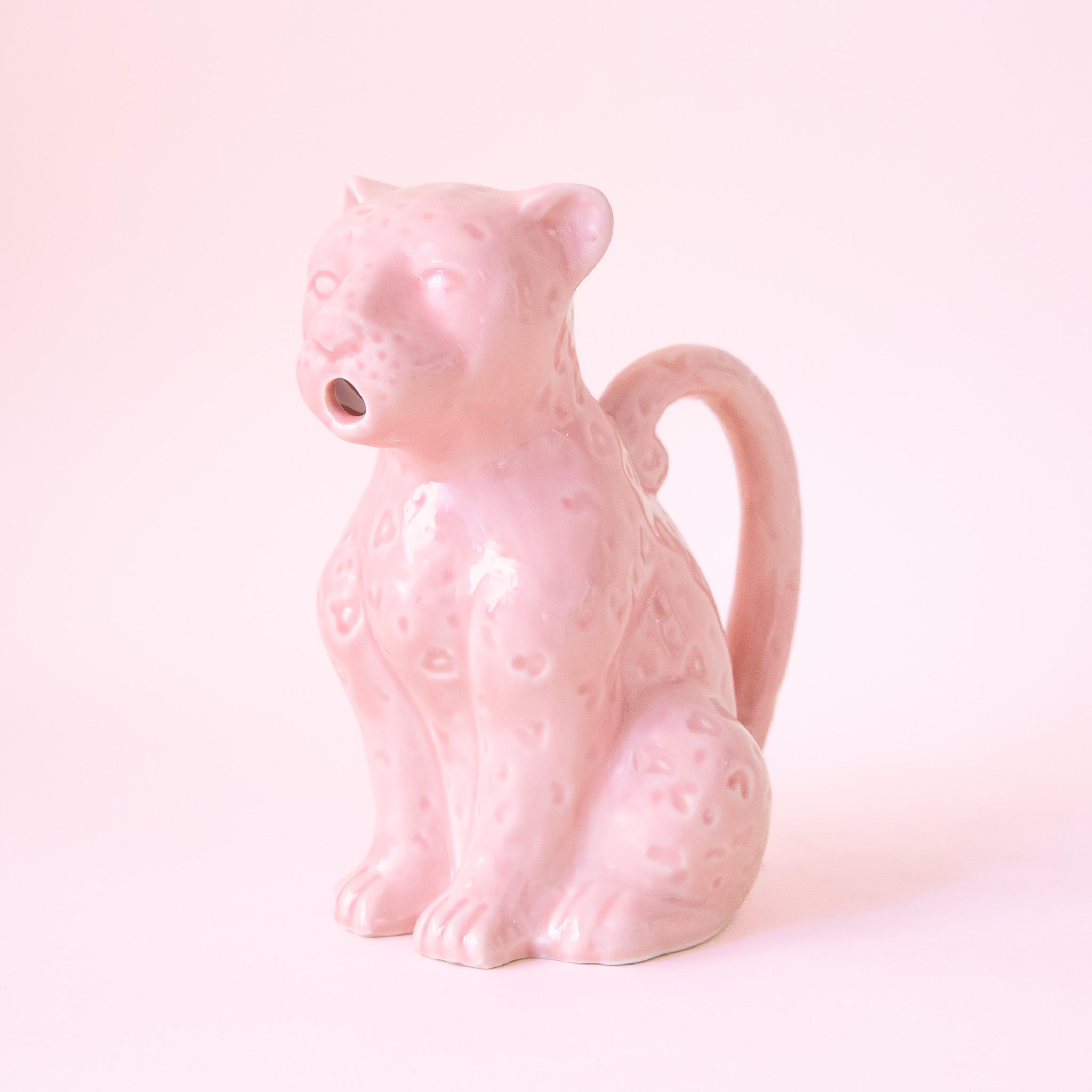 a ceramic pink, leopard shaped pitcher that could be used for kitchen use or plant watering. 