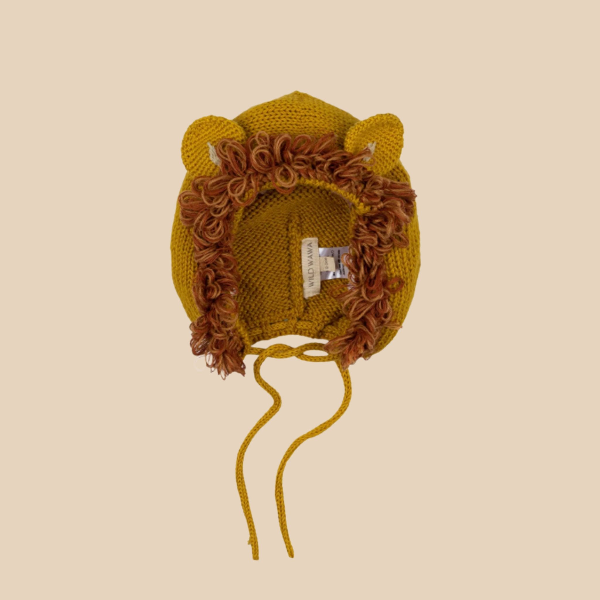 A mustard yellow knitted bonnet with a tie at the bottom and shaped like a lion's mane. 