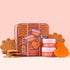 A gingerbread shaped house tin filled with a lip mask, a lip scrub and a silicone heart shaped lip exfoliator. 