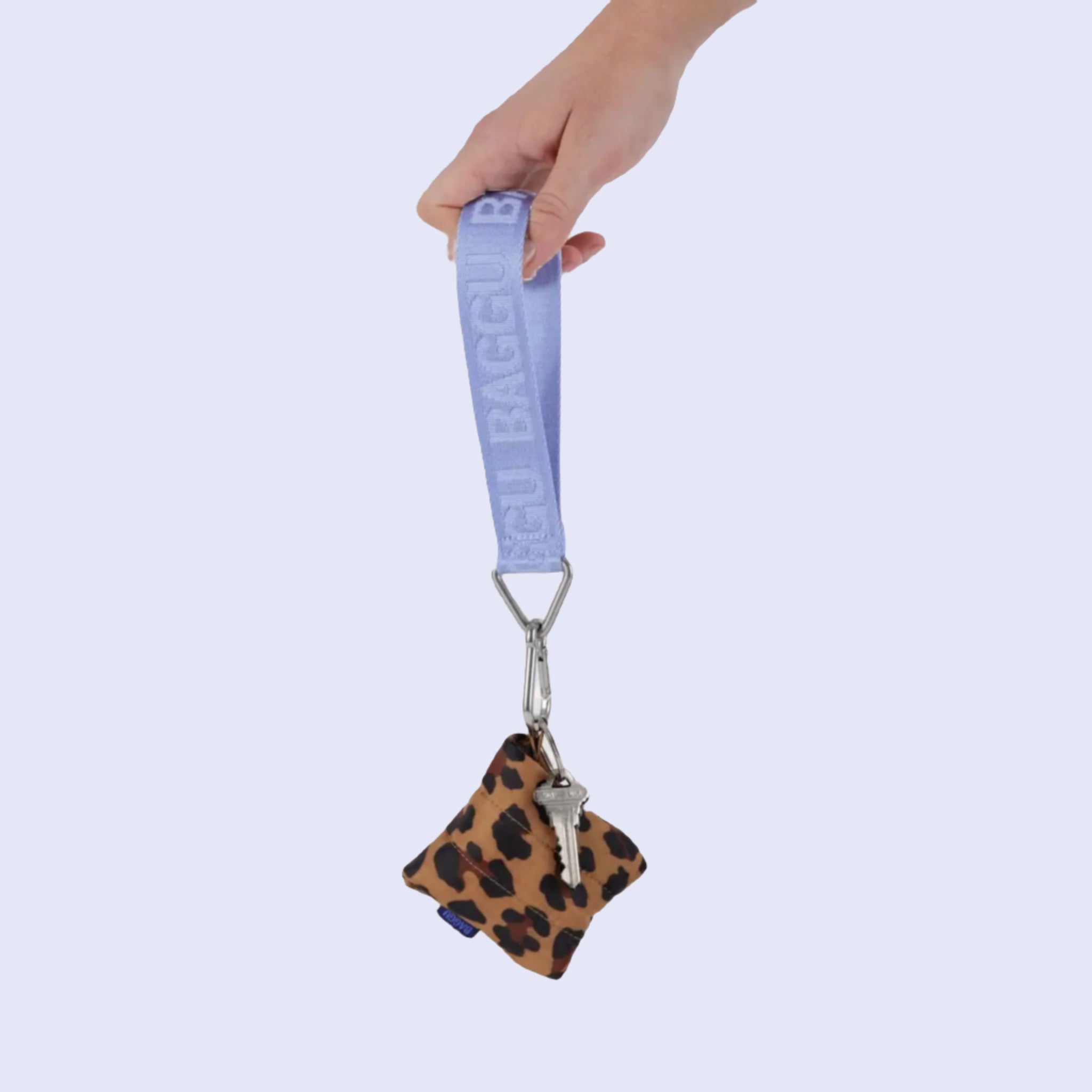 A light blue keychain with silver details and the &#39;Baggu&#39; logo on the lanyard. 