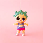 A glass LOL Surprise doll shaped ornament with blueish green hair and a purple outfit. 