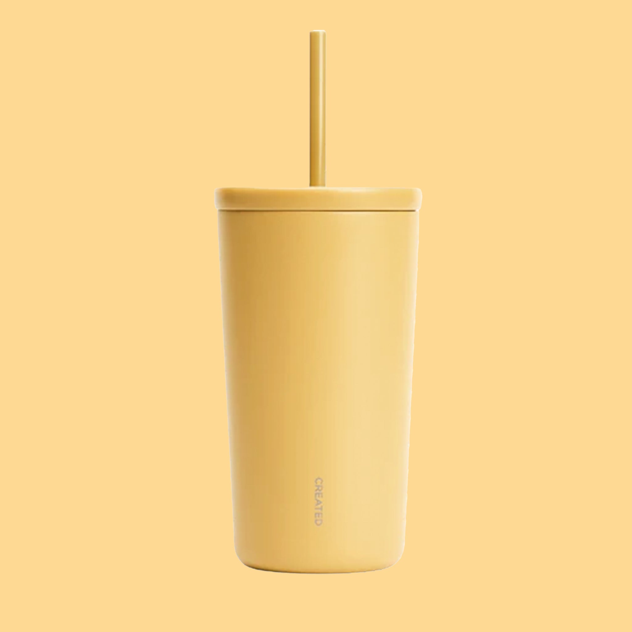 A yellow cold cup tumbler with a straw.