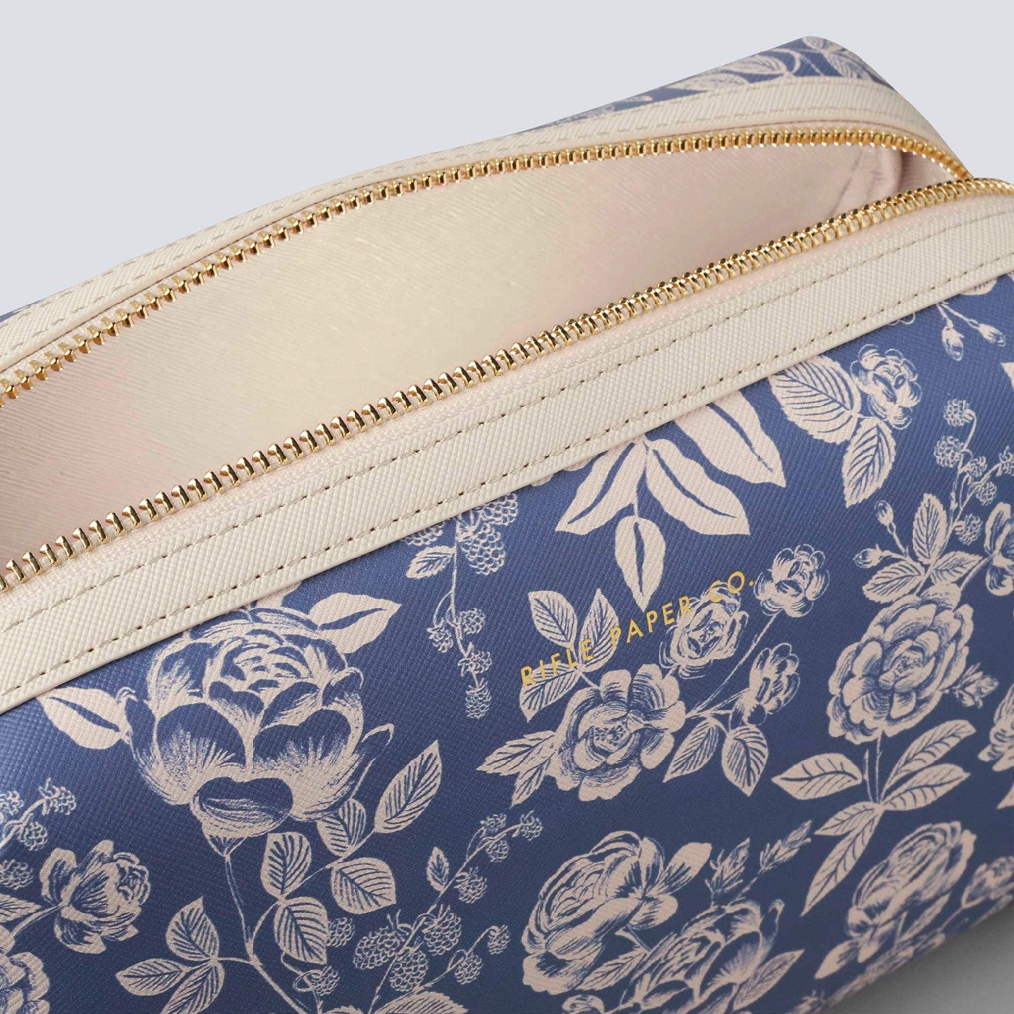 detailed view of blue cosmetic pouch with white flower pattern