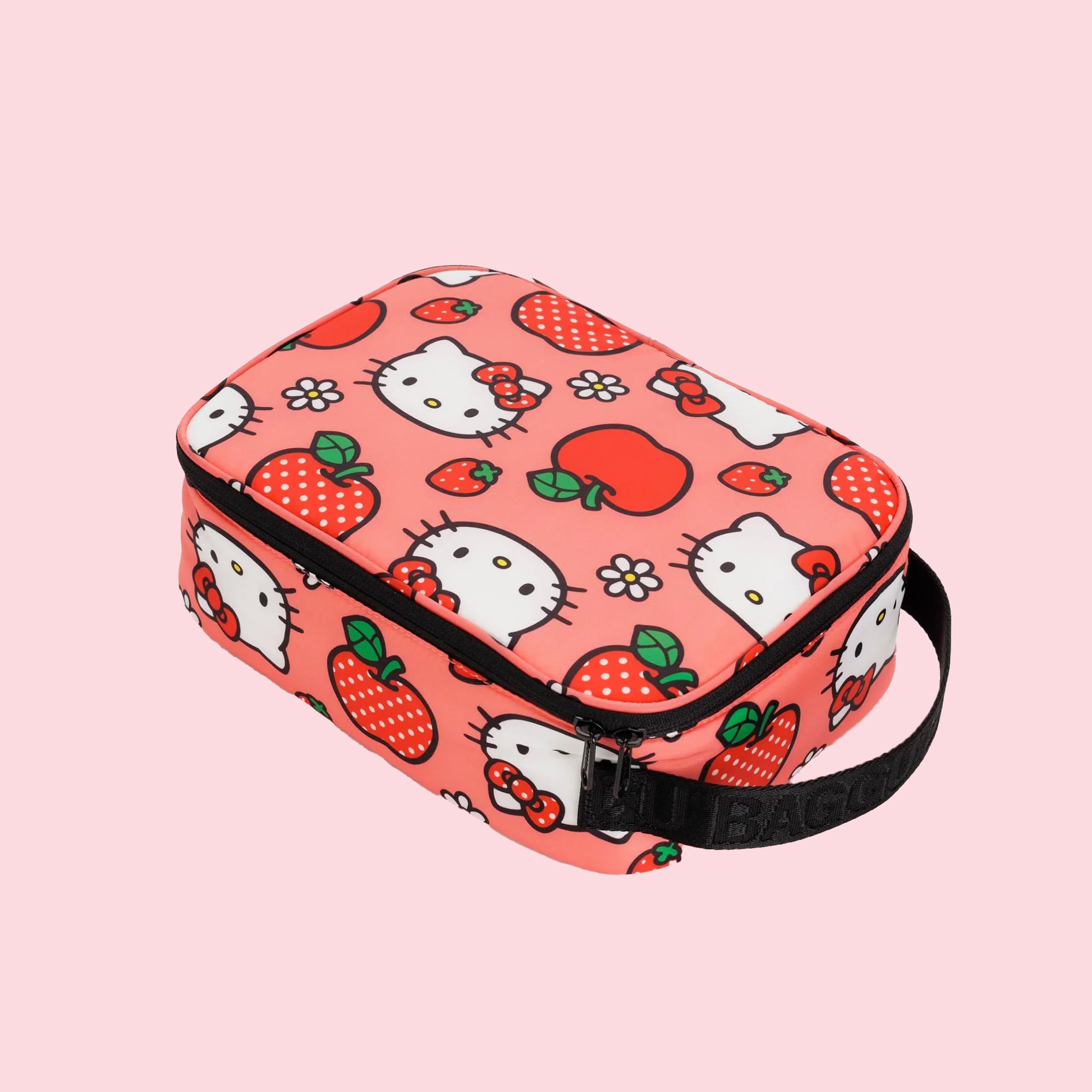 A pink and red lunch box with a Hello Kitty Apple pattern and black strap.