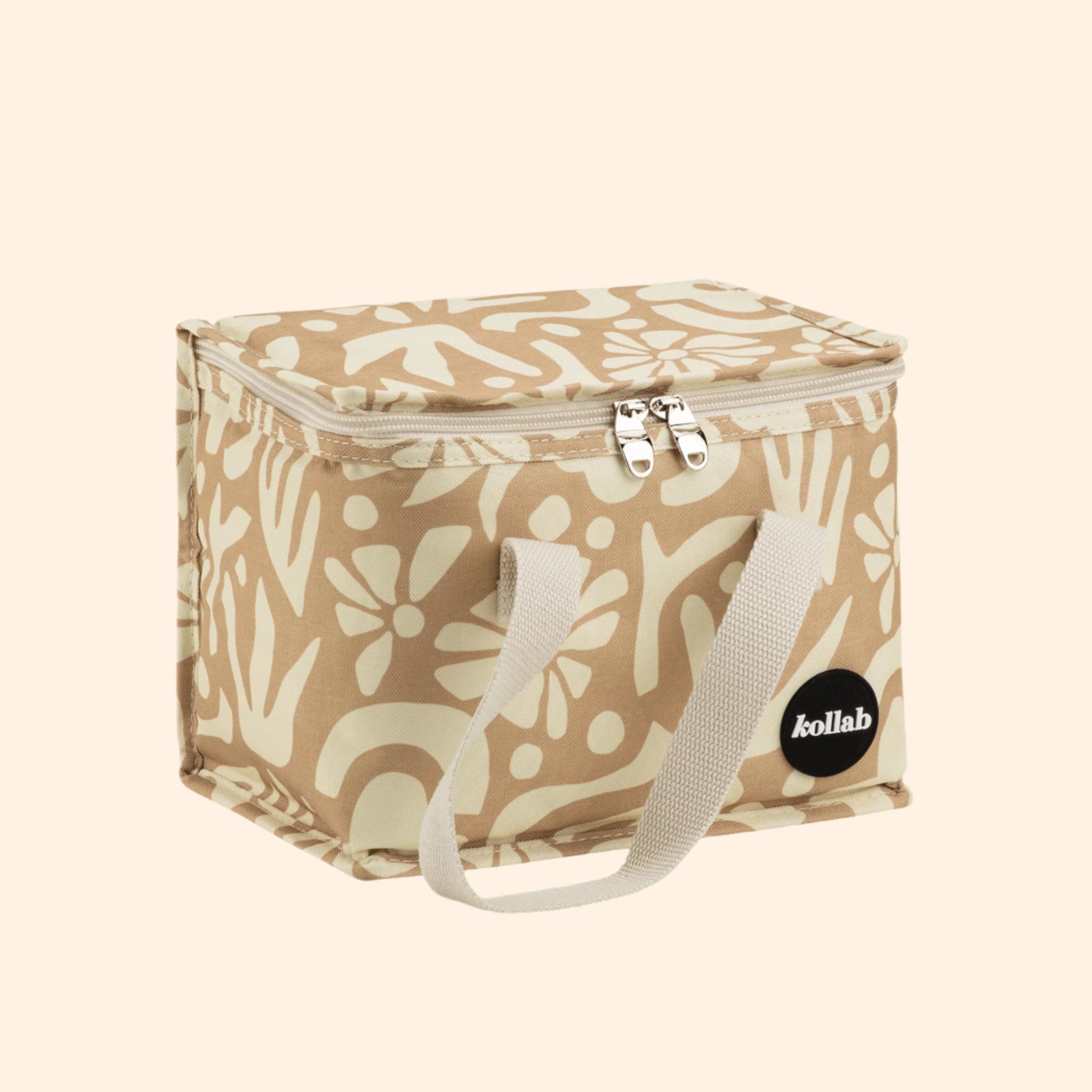 A tan floral print lunch box with canvas straps. 