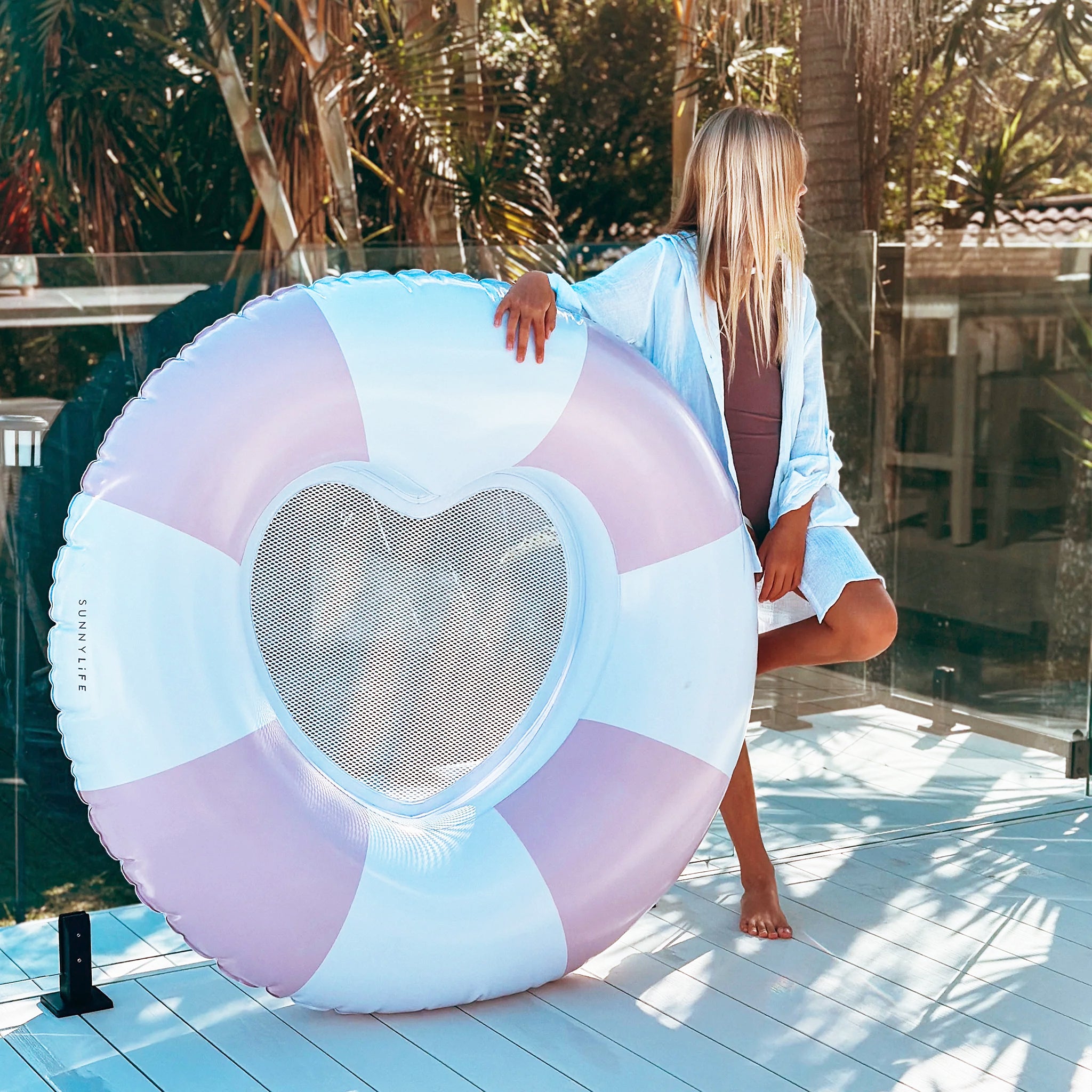 A pink and white striped pool float but the center is in the shape of a heart with a mesh backing. 