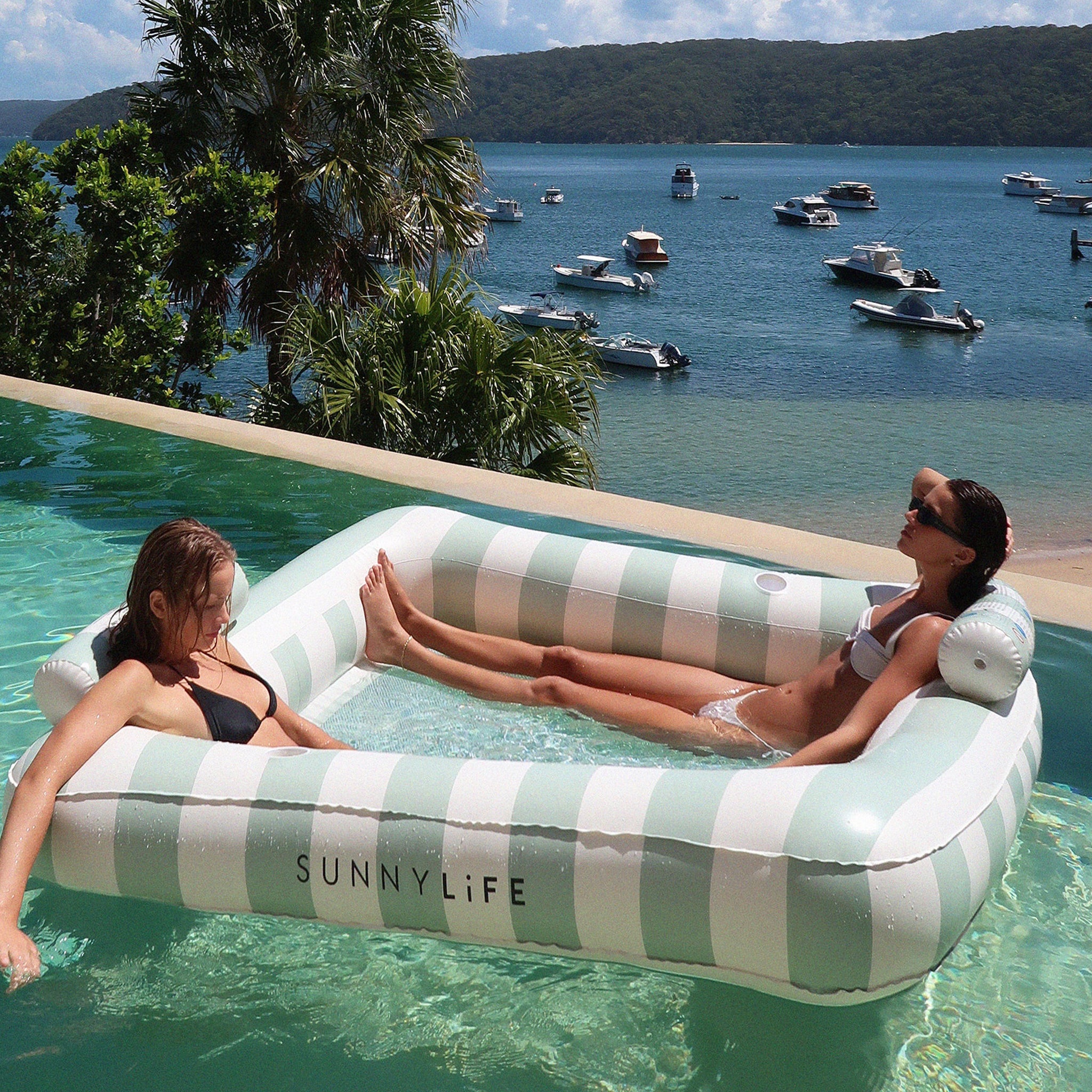 A green and white pool / water float with a neck rests on two of the sides. 