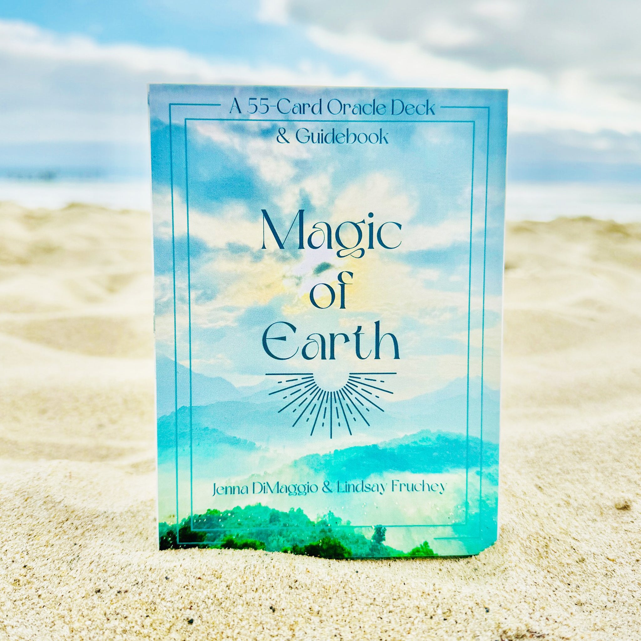 A deck of cards with a box cover of the sky and landscape and text that reads, "55 Card Oracle Deck & Guidebook Magic of Earth". 
