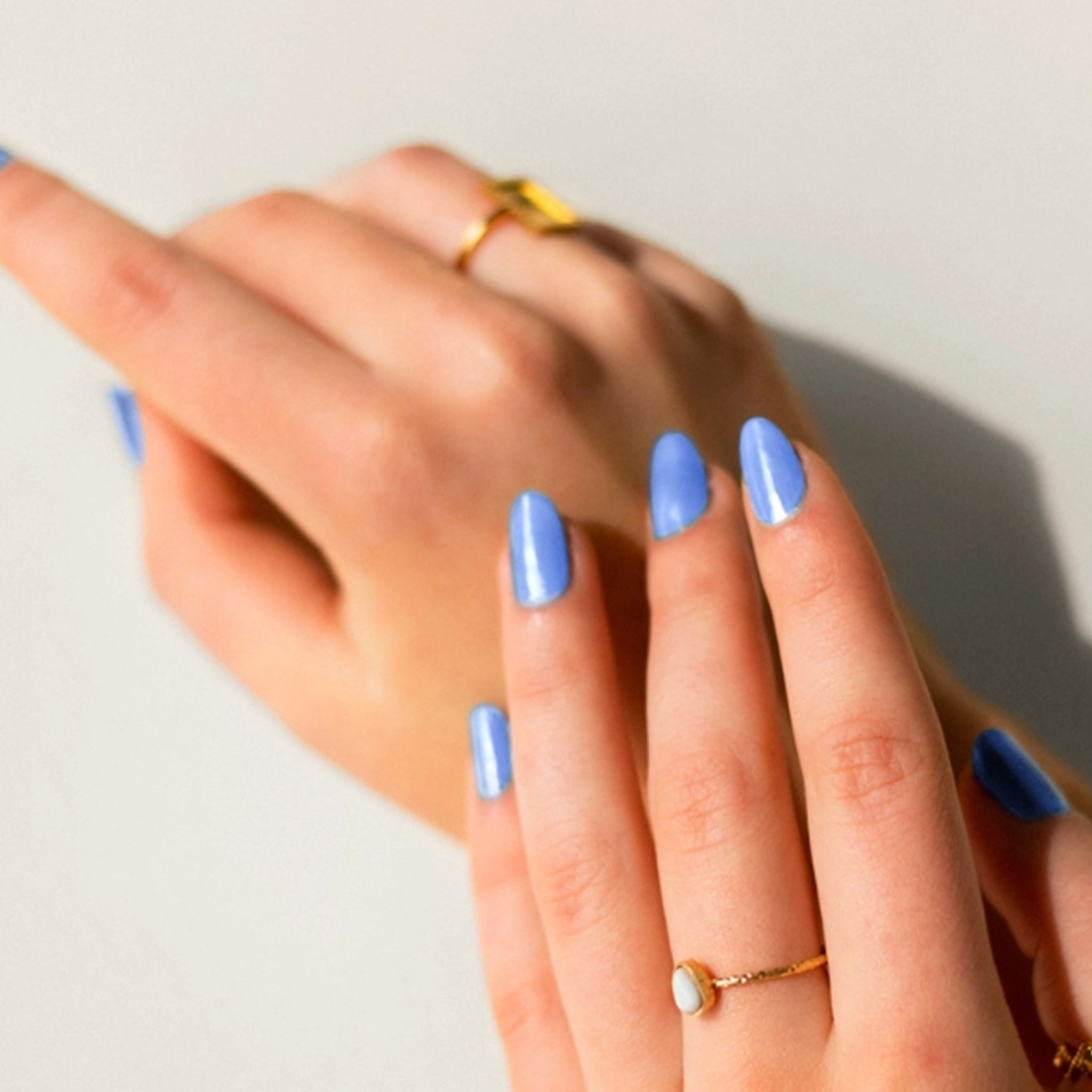 A blue nail polish in rectangle glass bottle. 