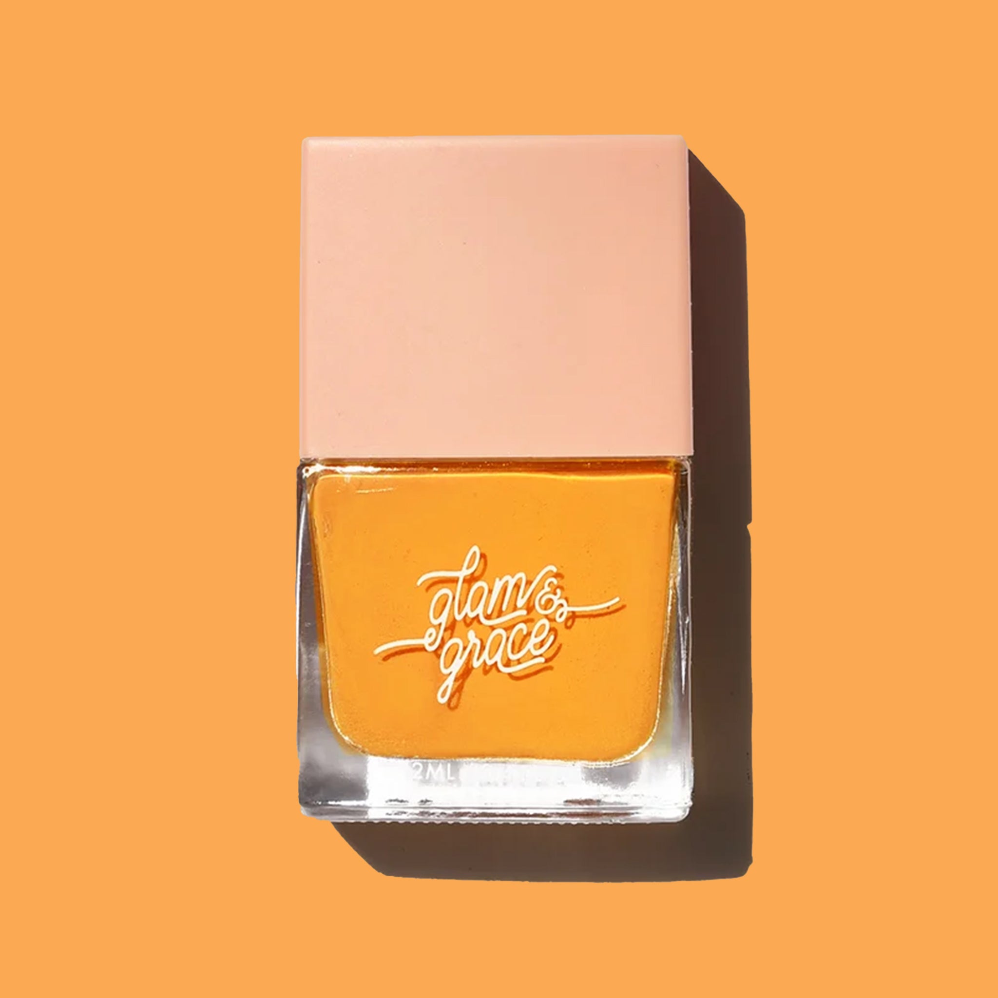 On a orange / yellow background is a square bottle of nail polish. 