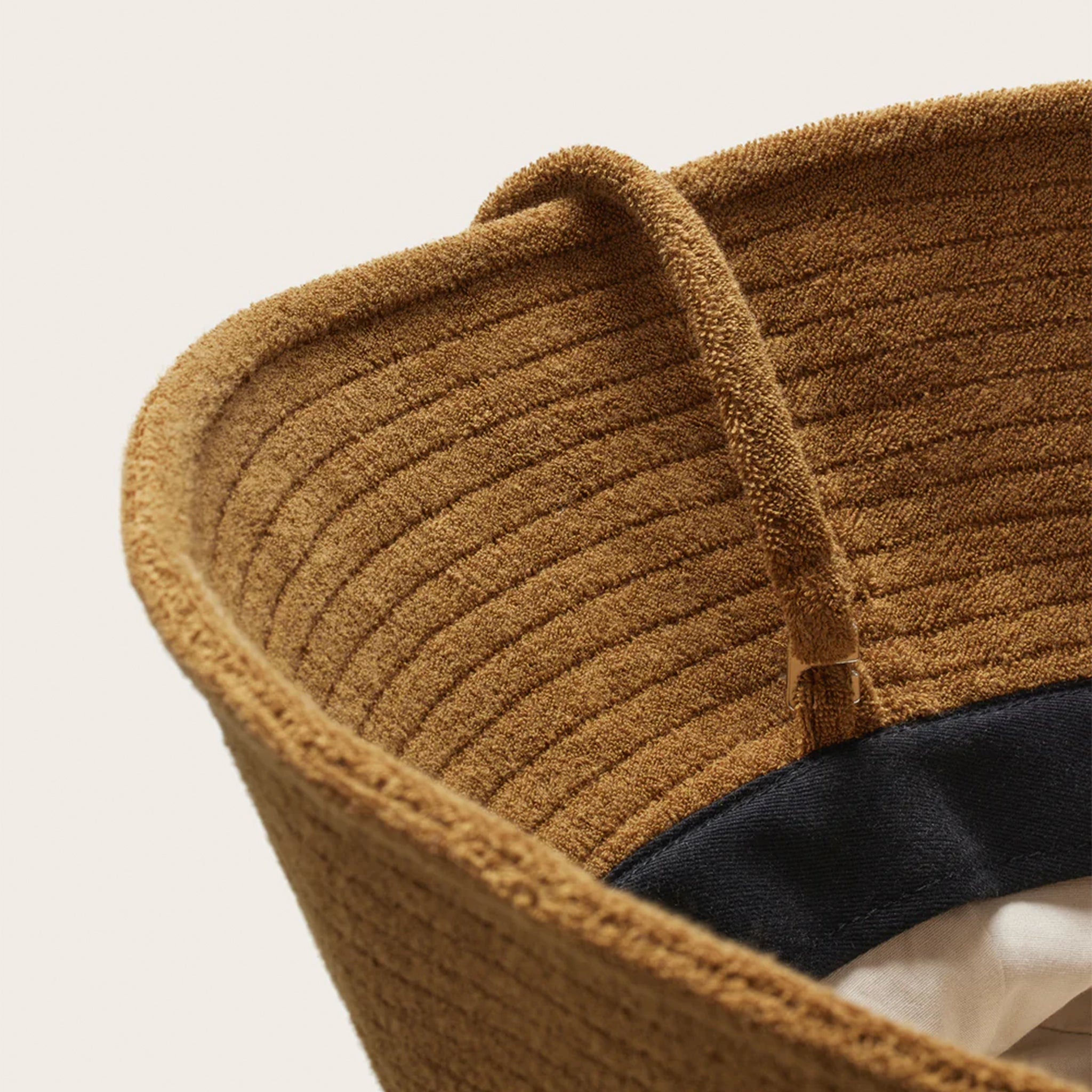 A brown bucket hat with a ribbed brim and removable draw string.