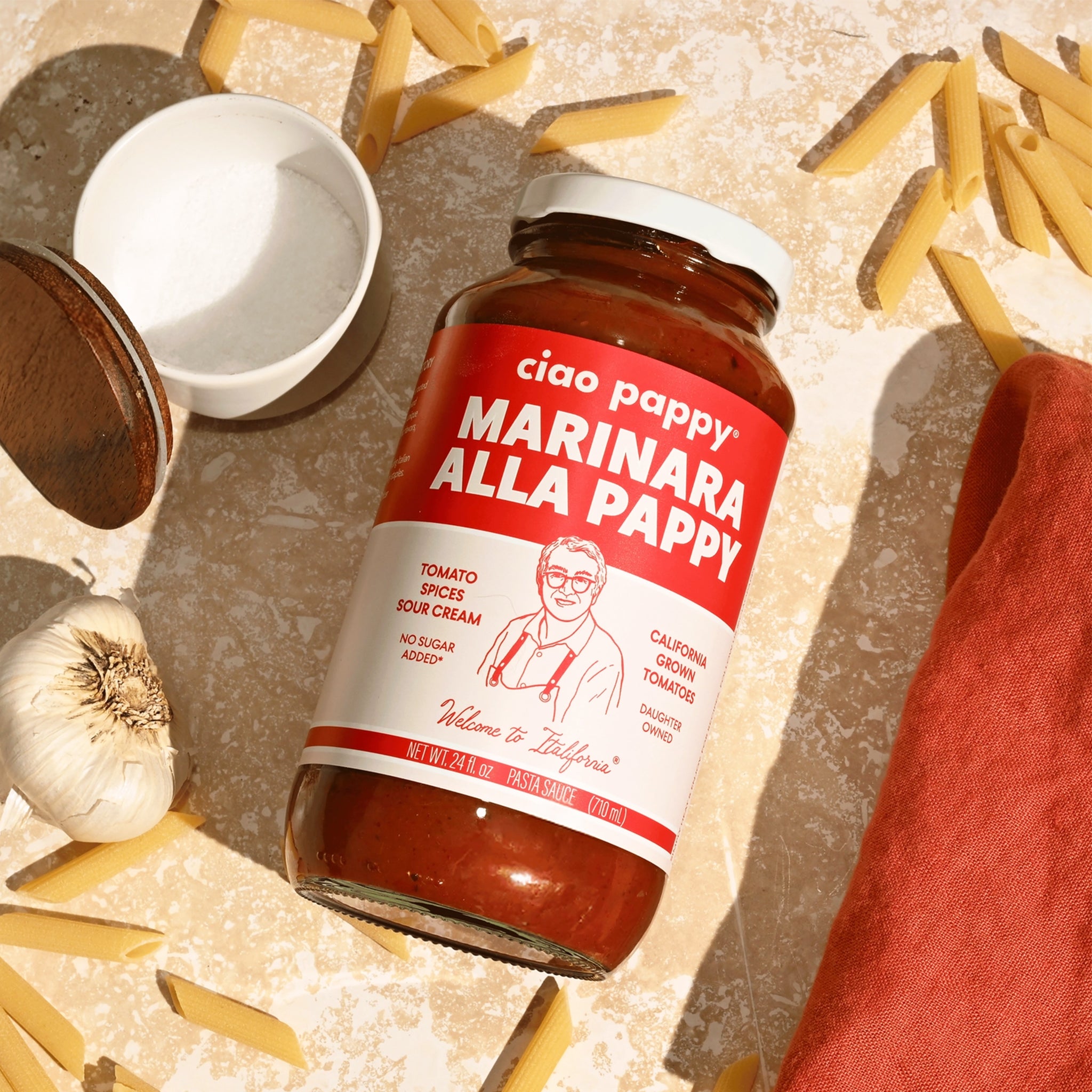 A glass jar of marinara sauce with white text that reads, &#39;ciao pappy Marinara Alla Pappy&#39;. 