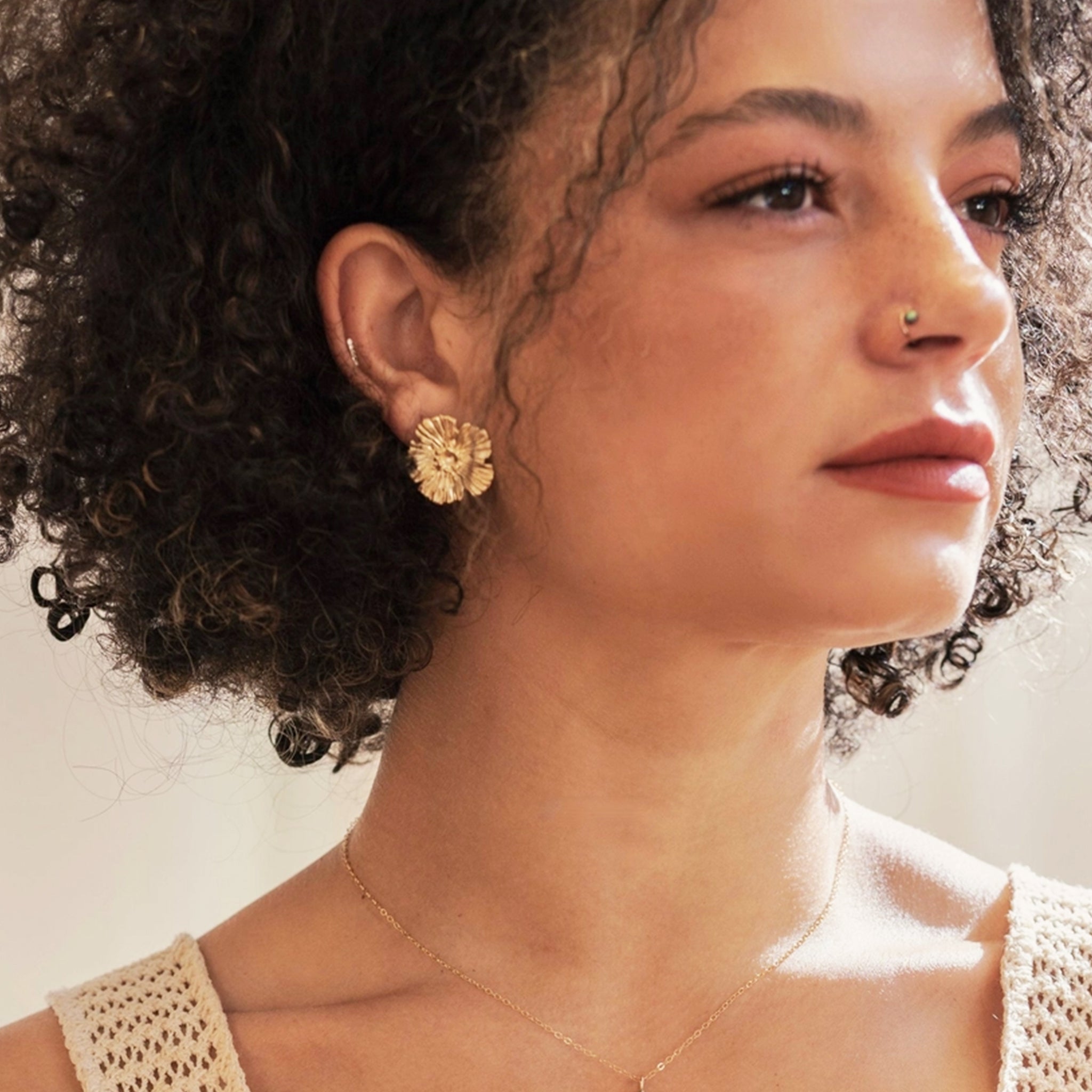 A gold pair of flower shaped earrings. 